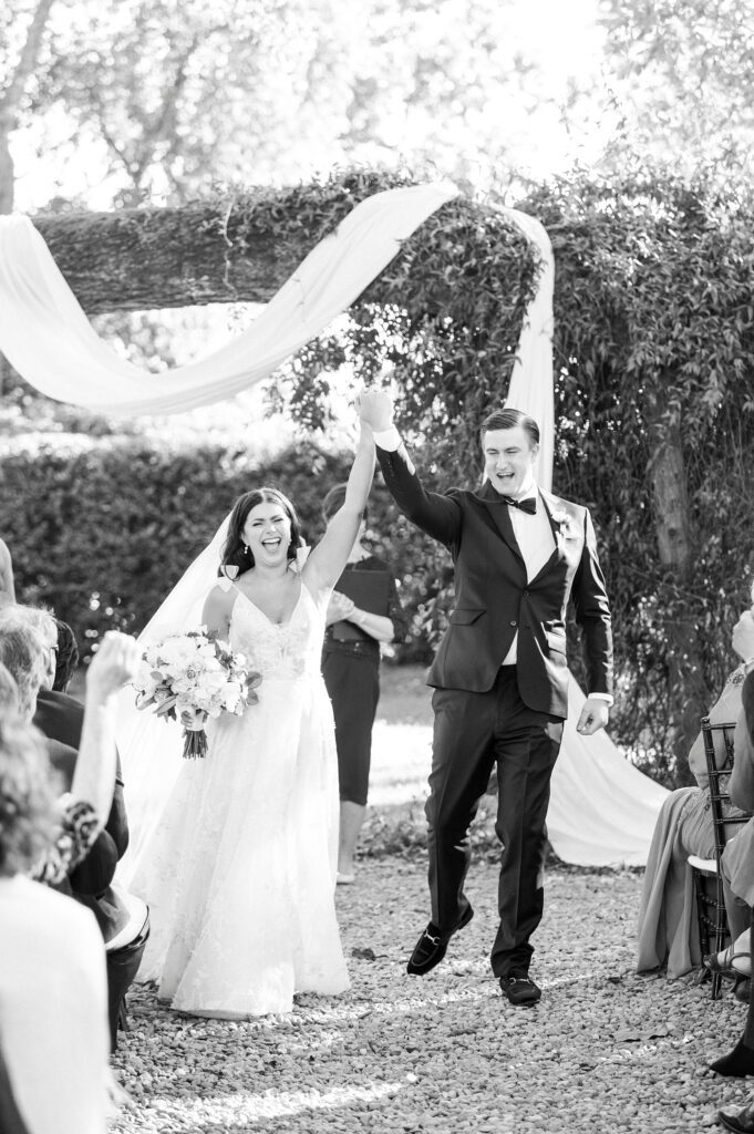 bride and groom cheer after wedding ceremony under oak at Whitehead Manor