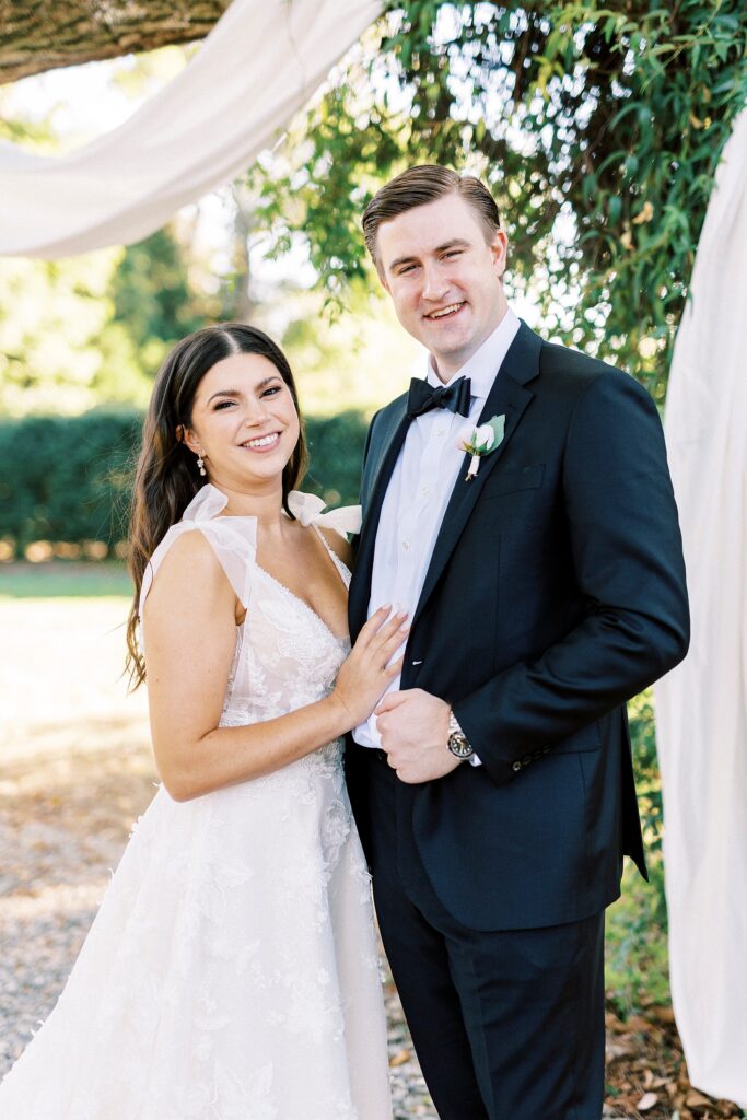 bride and groom hug smiling near oak tree at Whitehead Manor