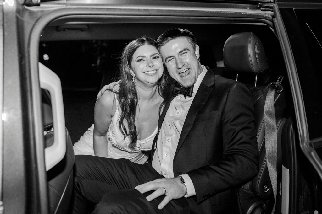 bride and groom hug in classic car at Whitehead Manor