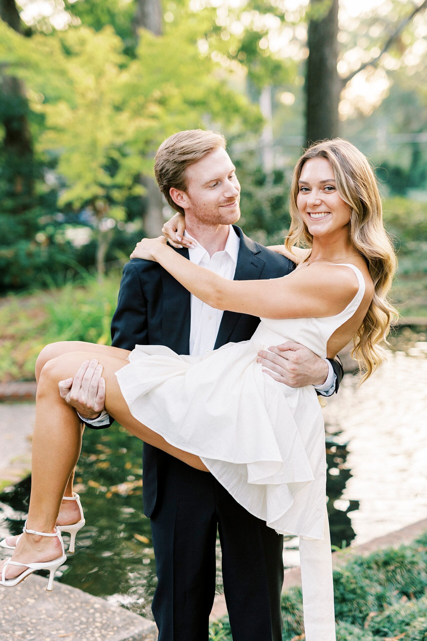 man in suit lifts up woman in white dress