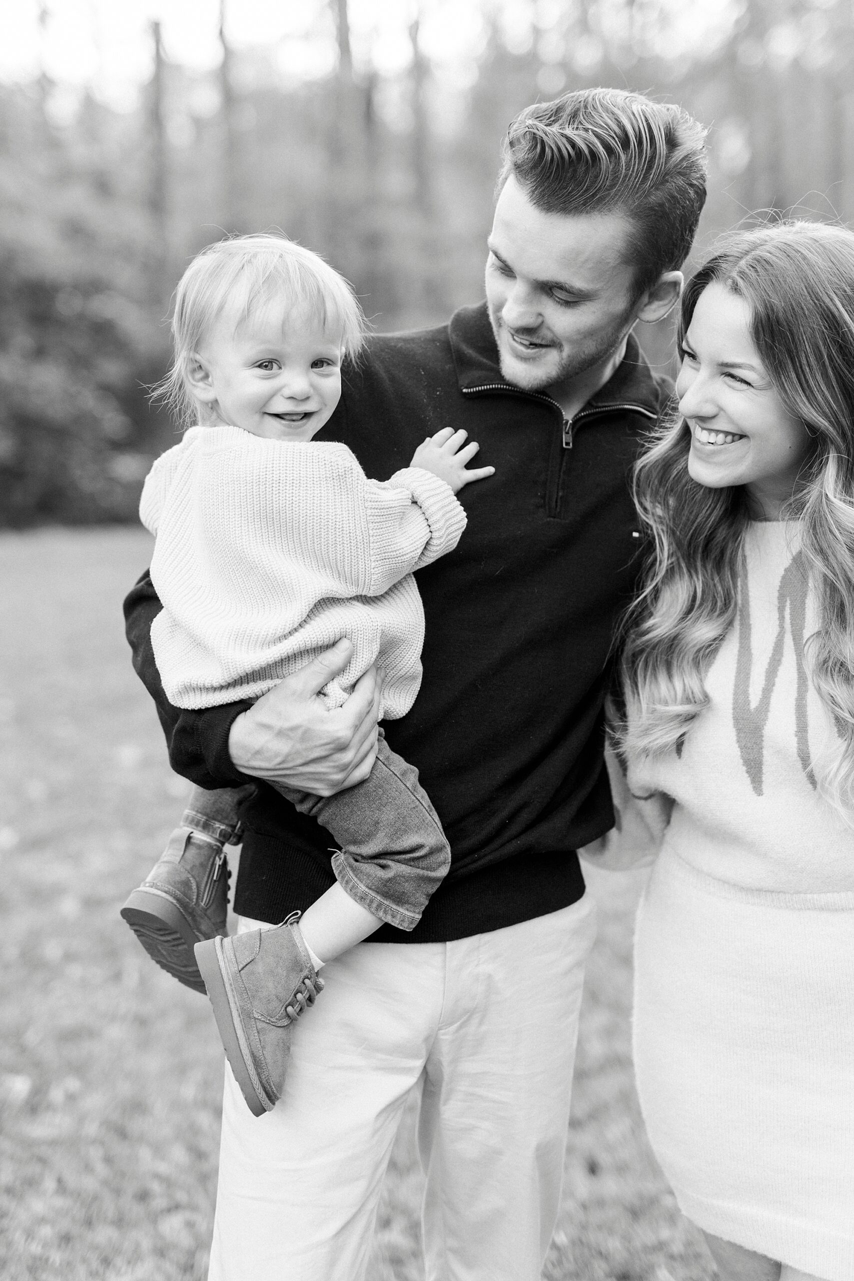 blonde toddler hugs dad during fall family photos at Baker's Creek Park