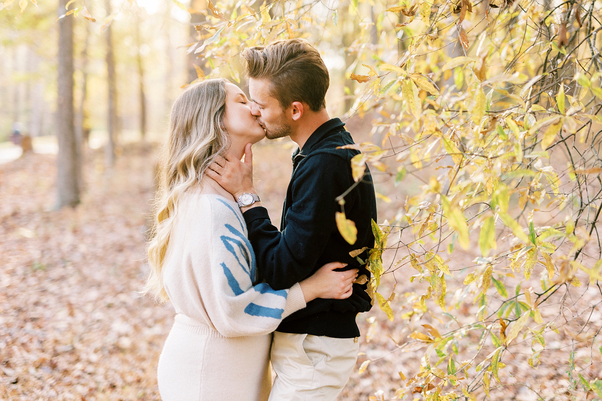 engaged couple kisses in woods of Baker's Creek Park