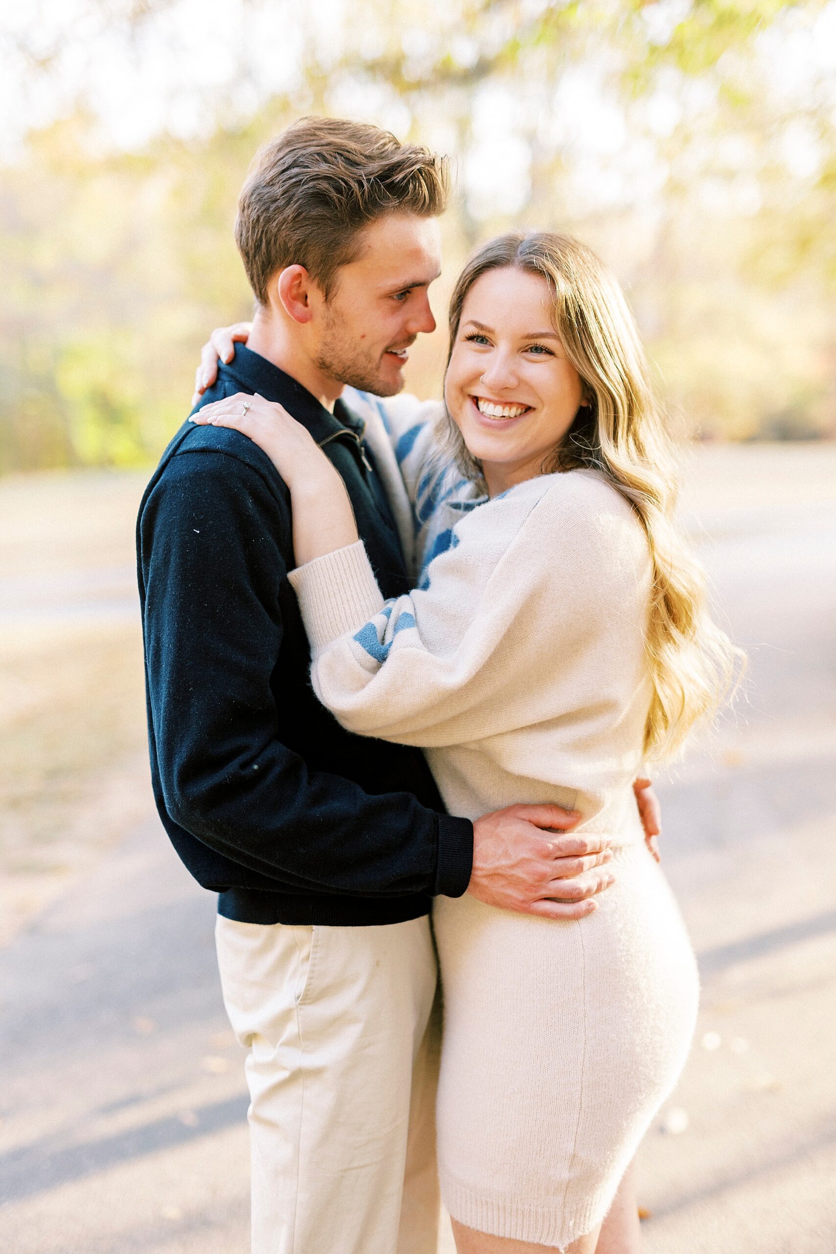 engaged couple hugs while man makes woman laugh 