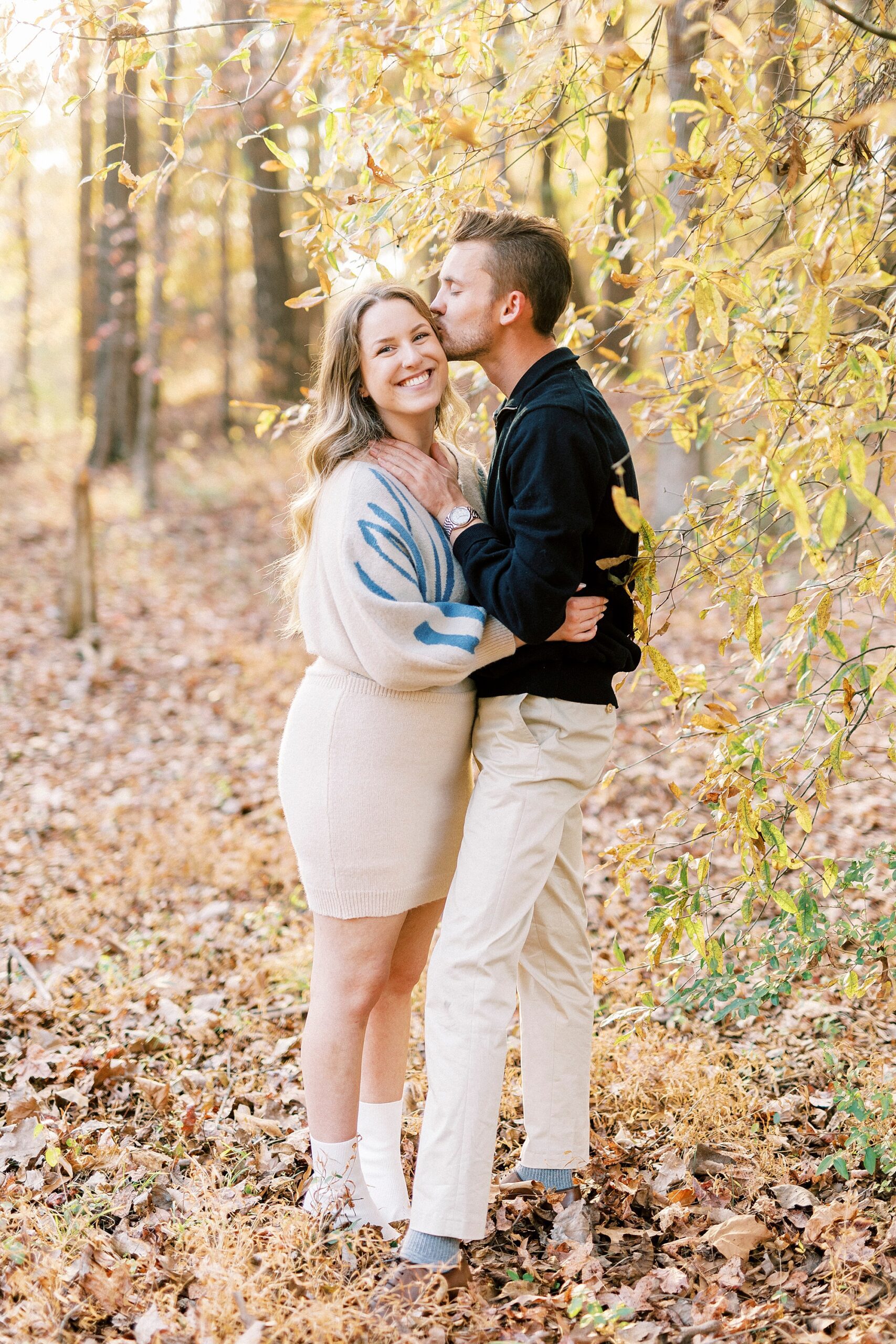 man kisses woman's forehead while holding her neck in Baker's Creek Park