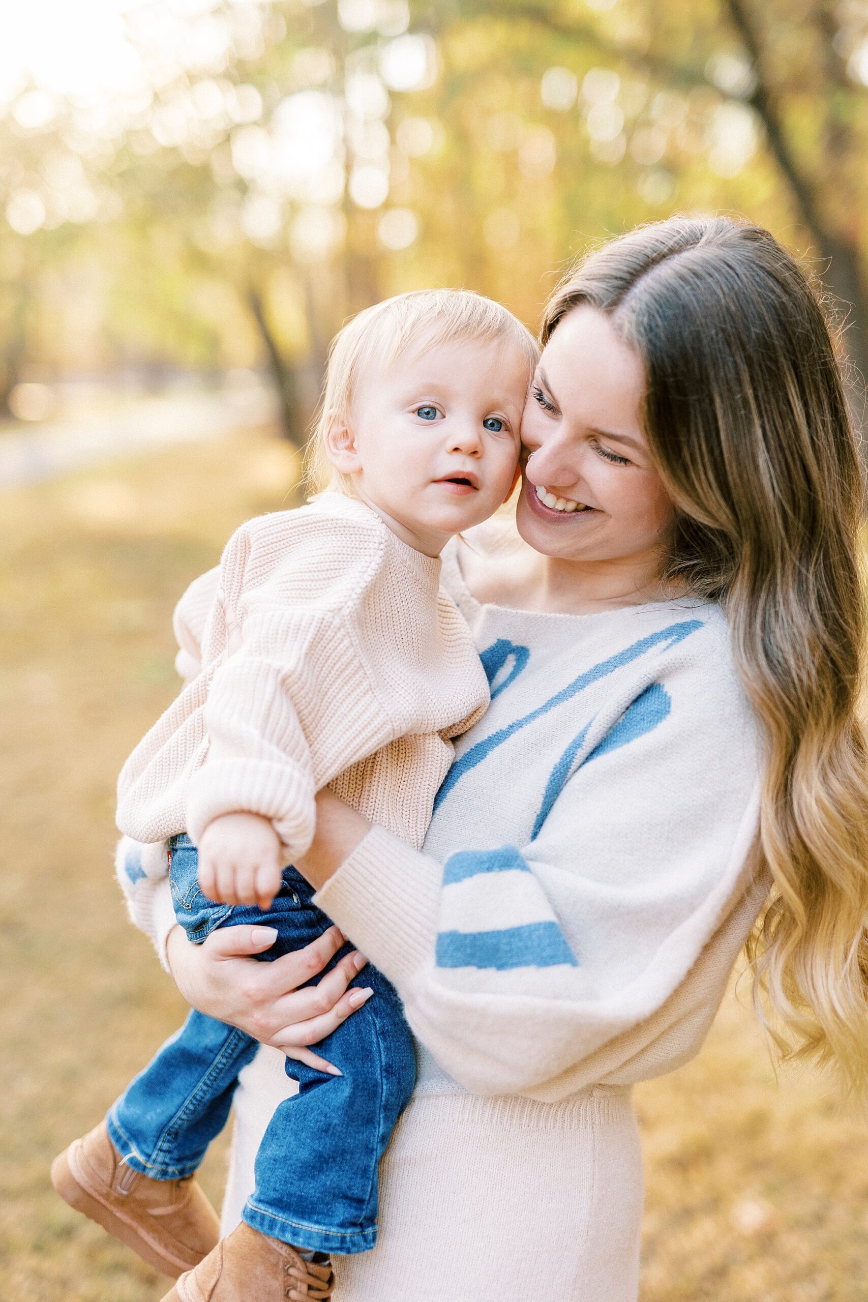 mom laughs holding son to her during family photos in Baker's Creek Park