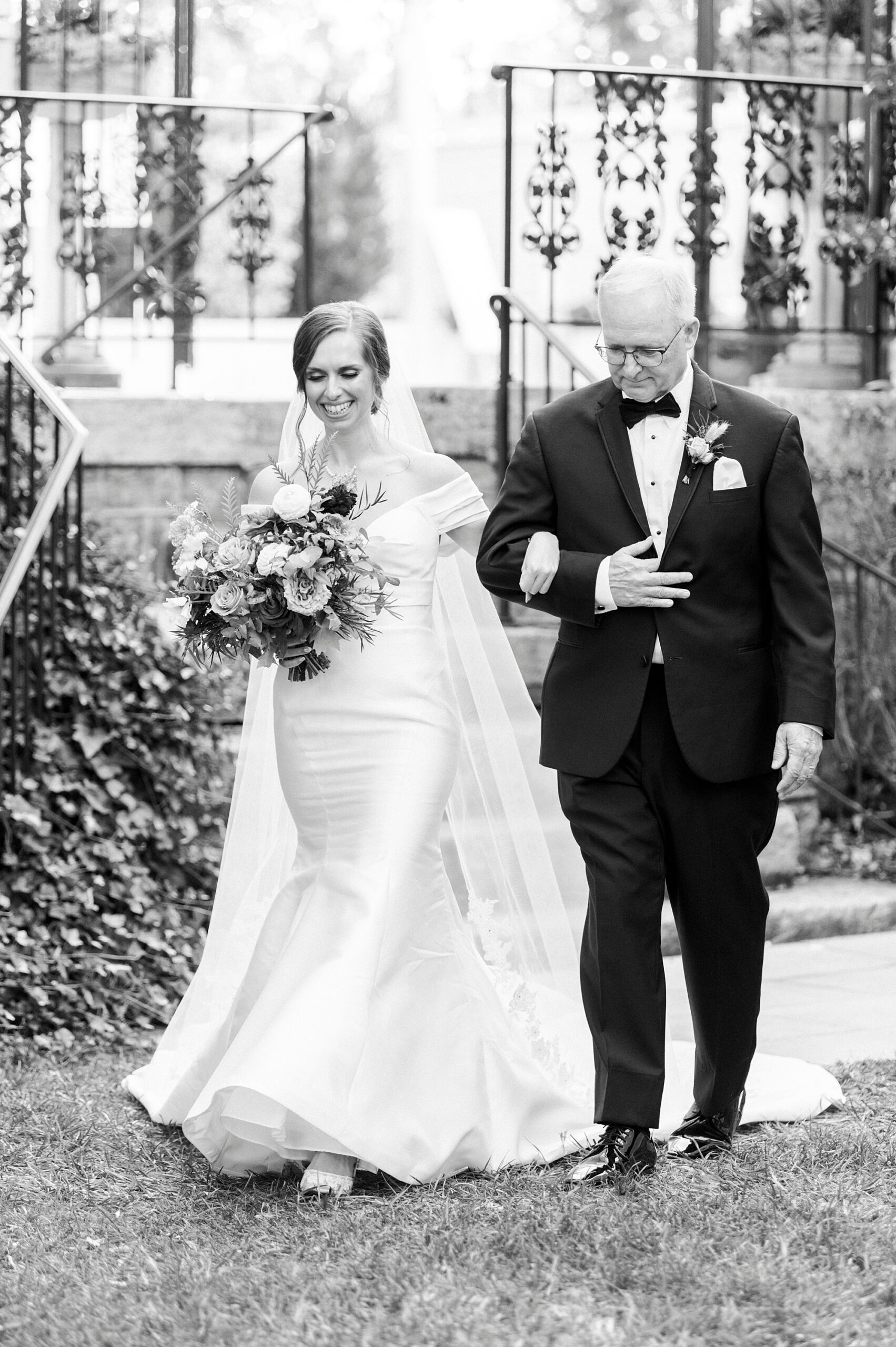 bride walks down steps at Separk Mansion with father for ceremony