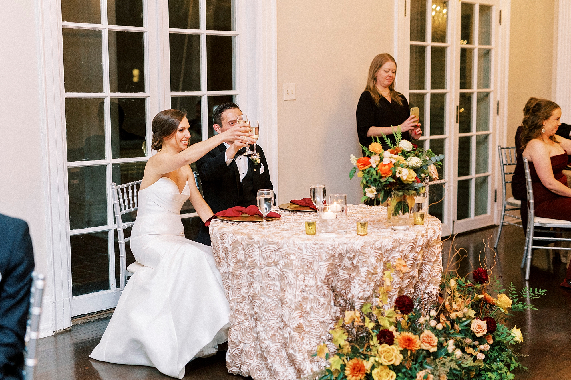 newlyweds lift glasses during NC wedding reception