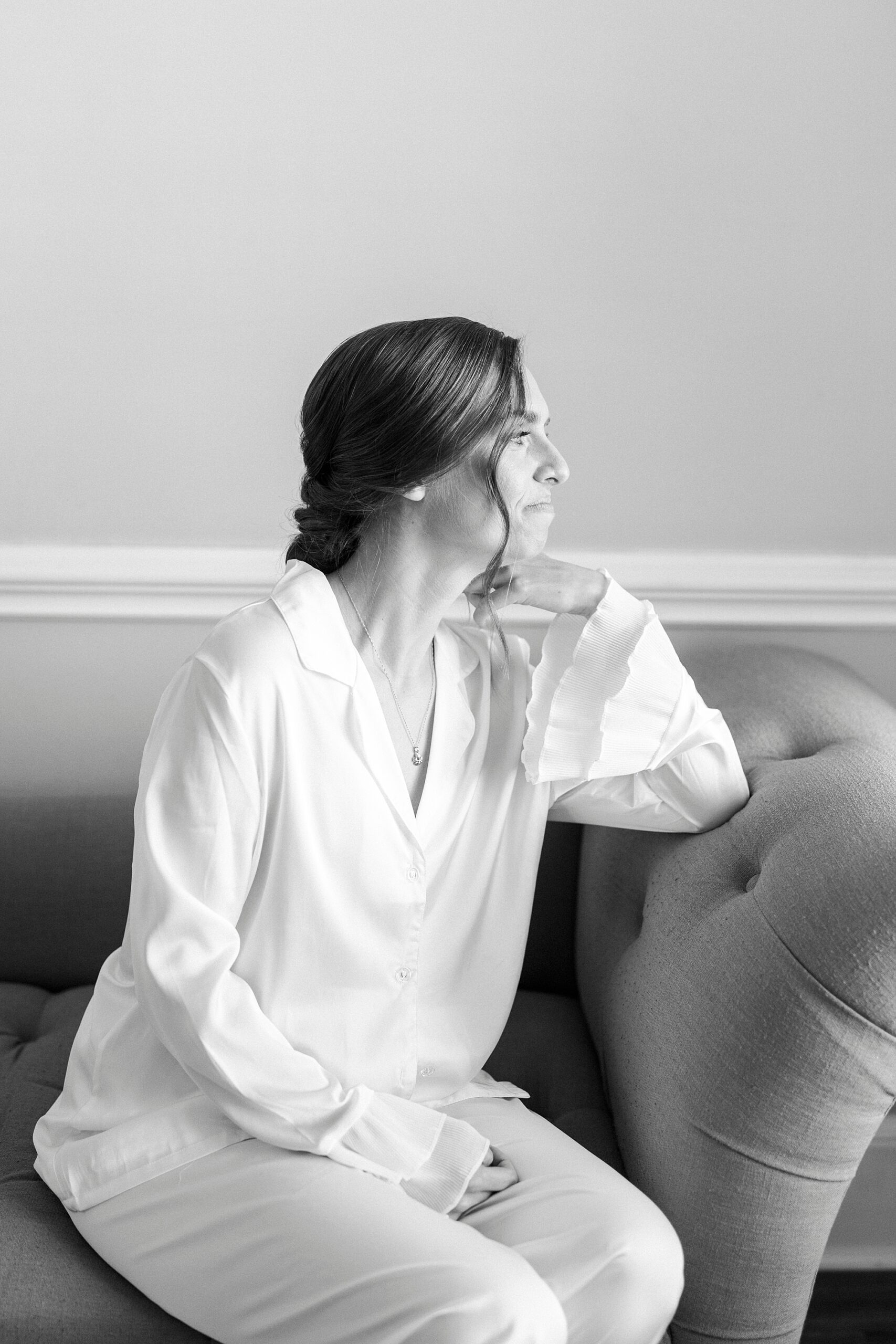 bride sits on sofa in suite at Separk Mansion looking out window
