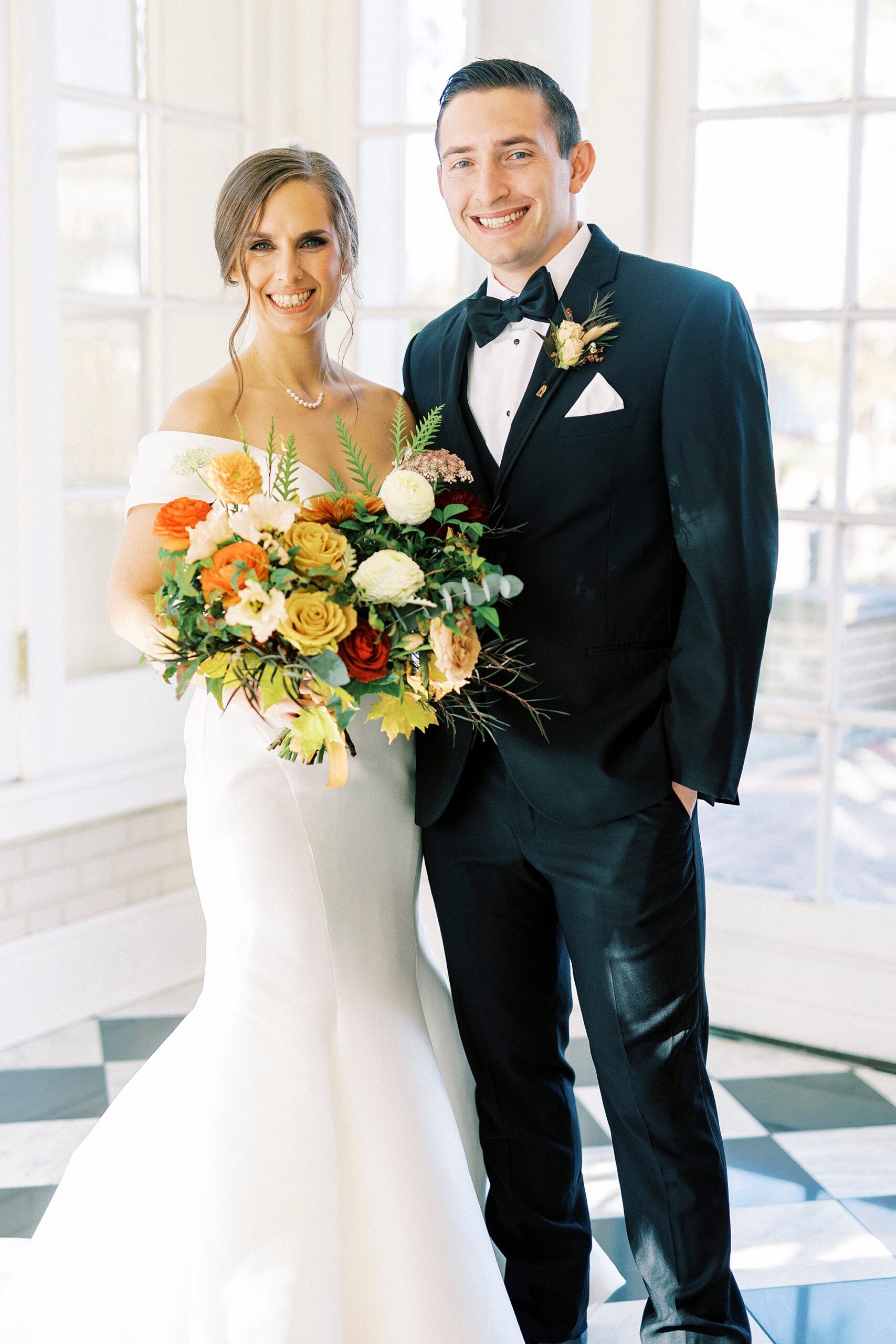newlyweds hug showing off bride's fall bouquet