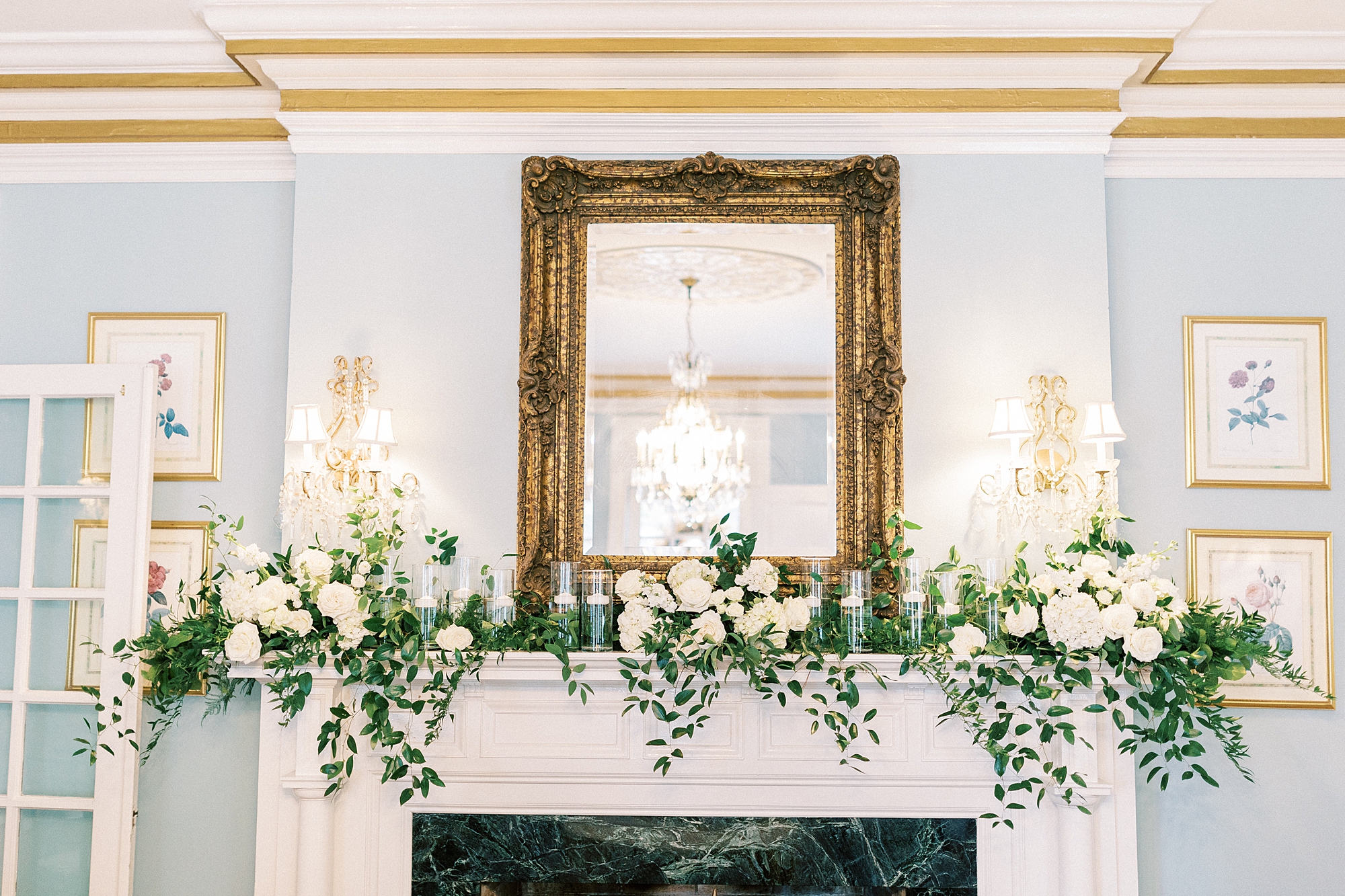 ivory flowers and greenery drape on mantel inside the Morehead Inn