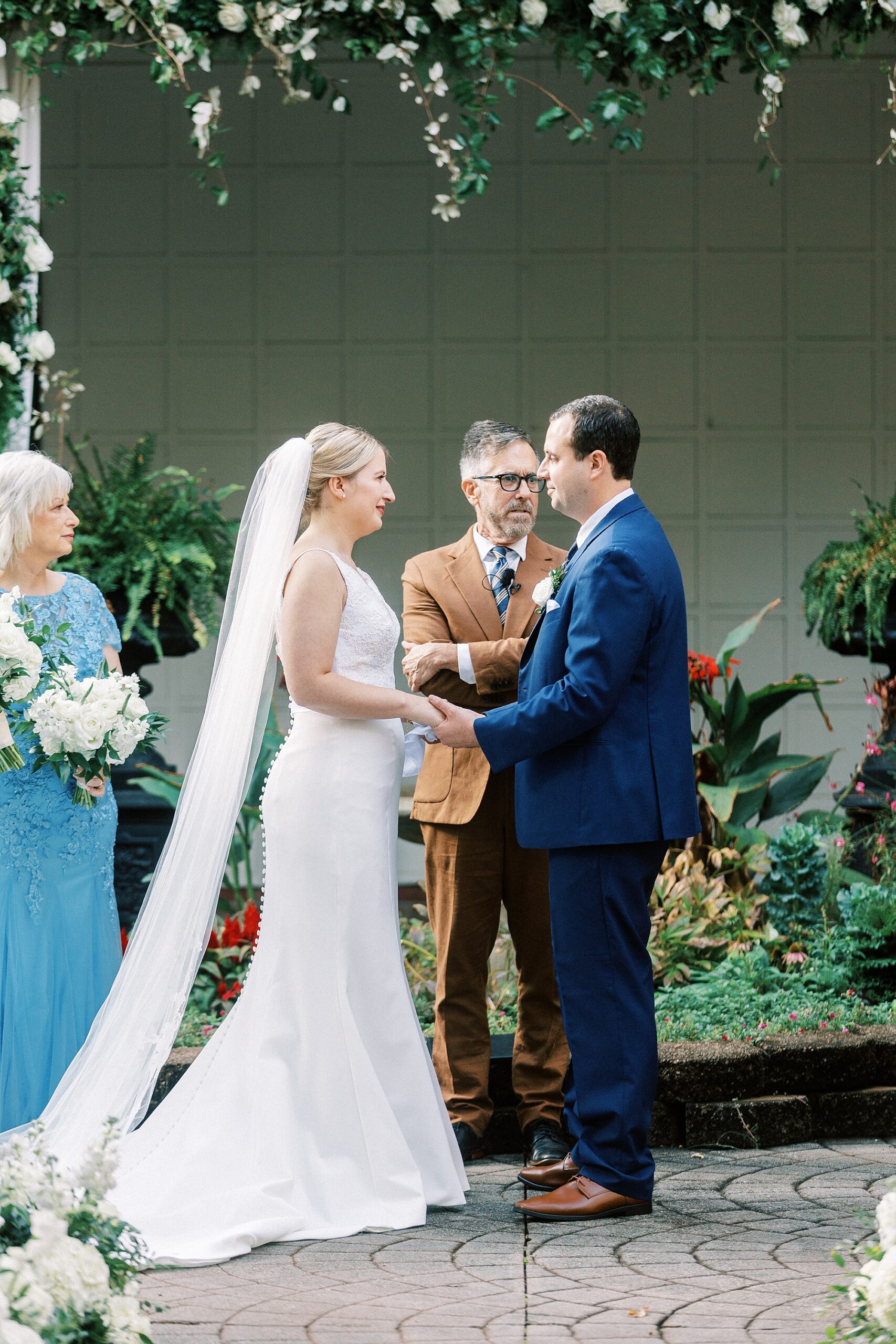 bride and groom hold hands exchanging vows during ceremony at the Morehead Inn