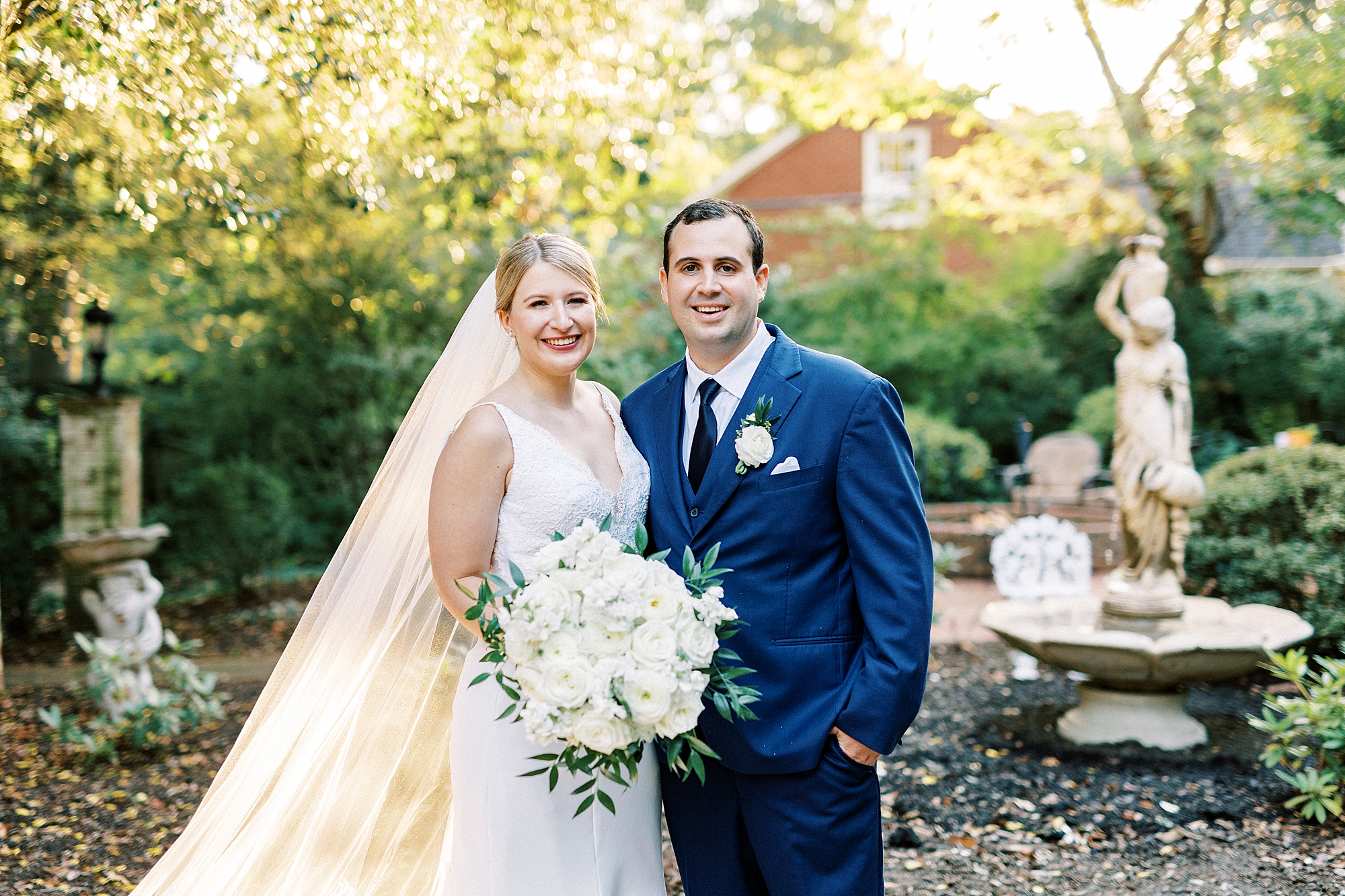 newlyweds hug by pond at the Morehead Inn