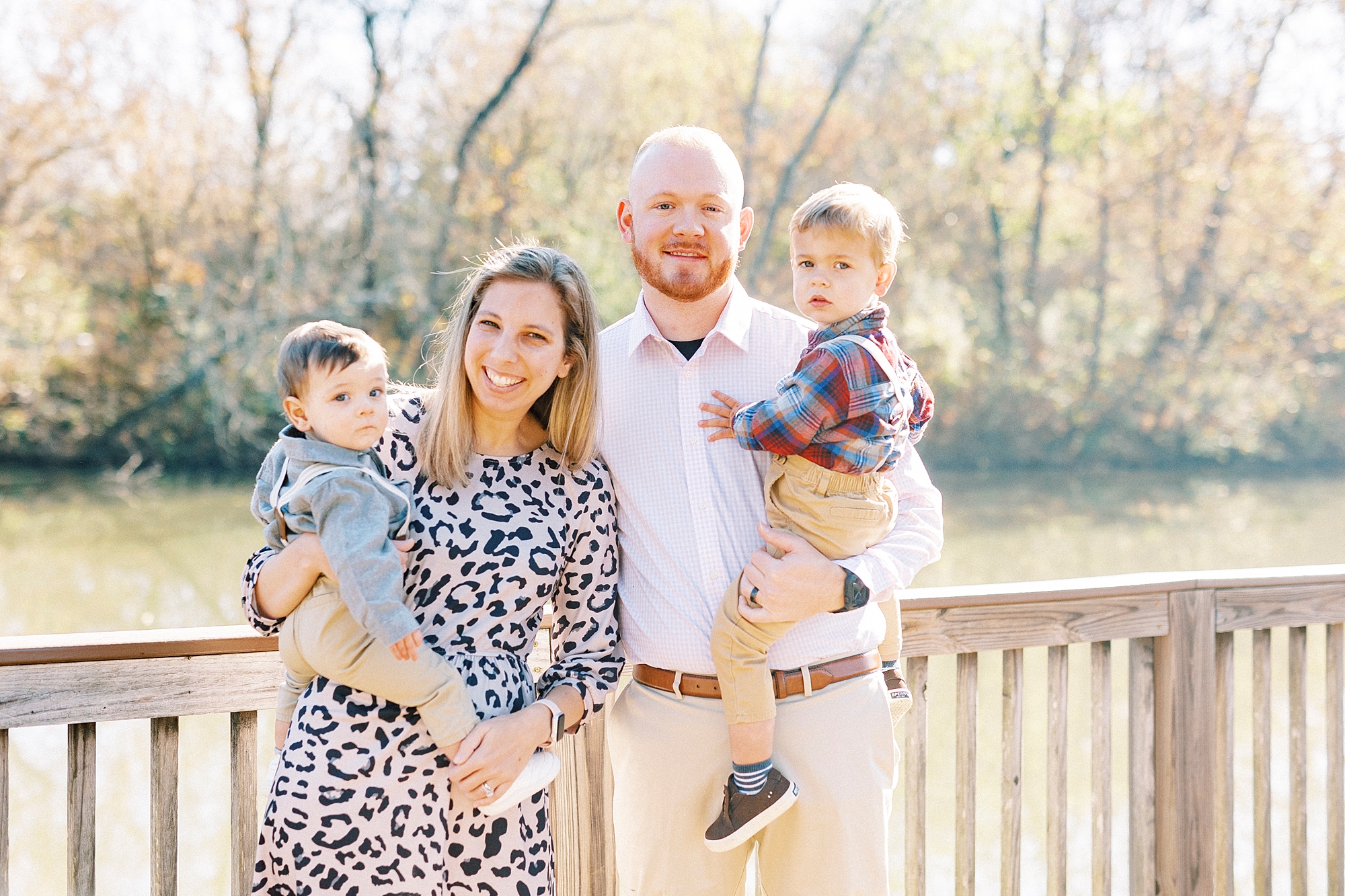 family of four poses on wooden bridge near Cramerton NC home