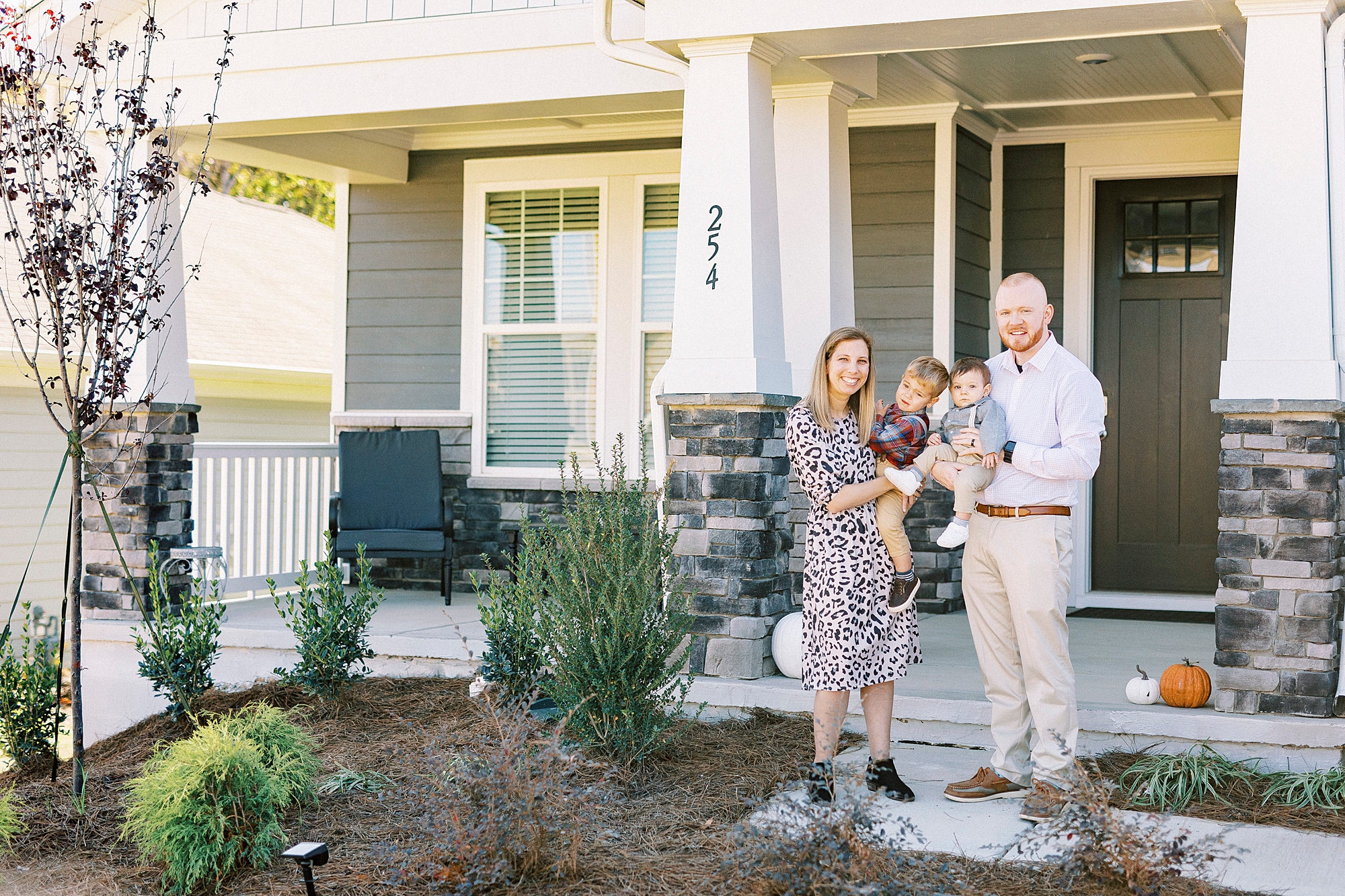 parents stand holding sons in front of home in North Carolina