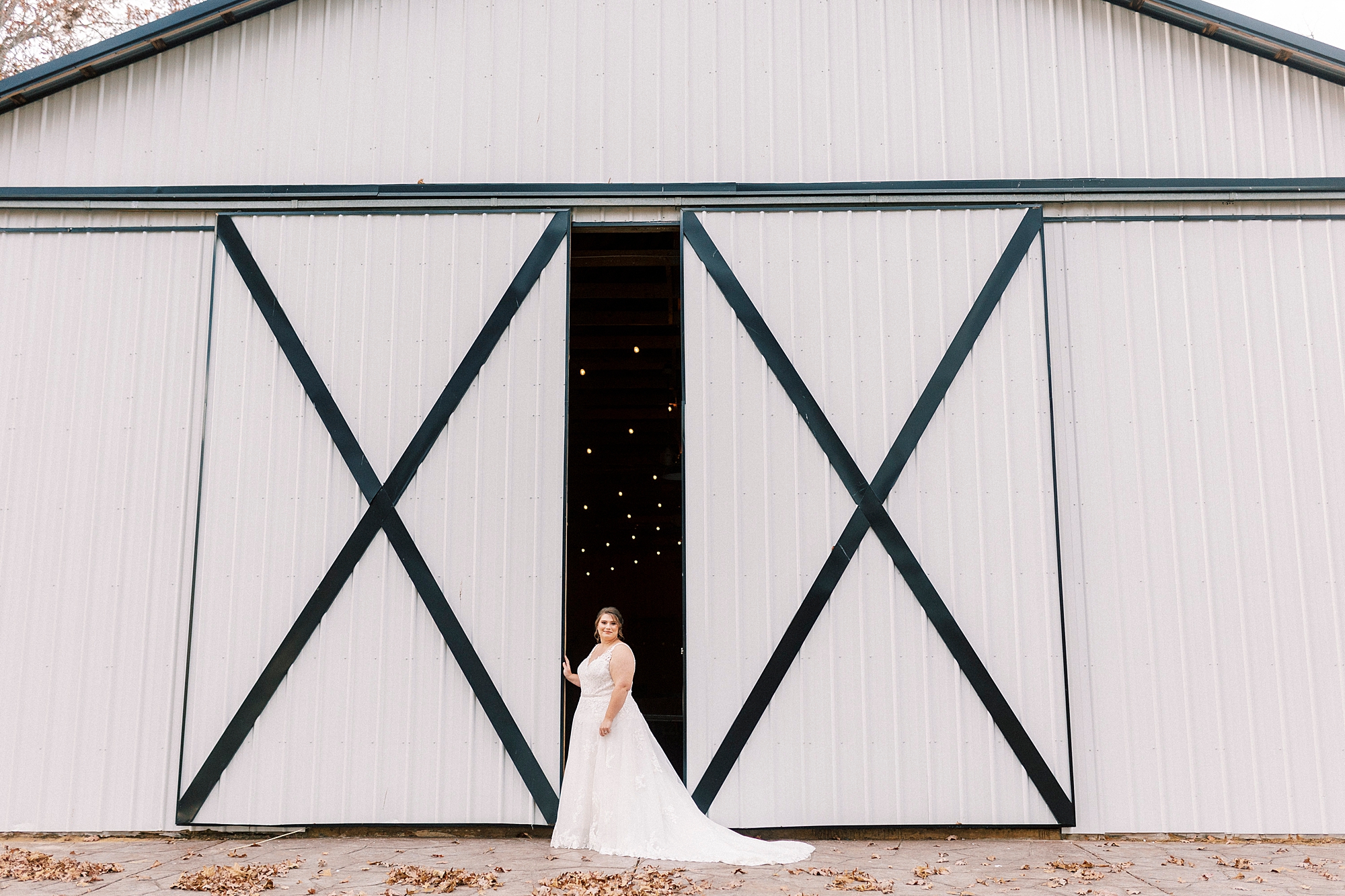 bride stands between barn doors during the Farm at Brusharbor bridal portraits