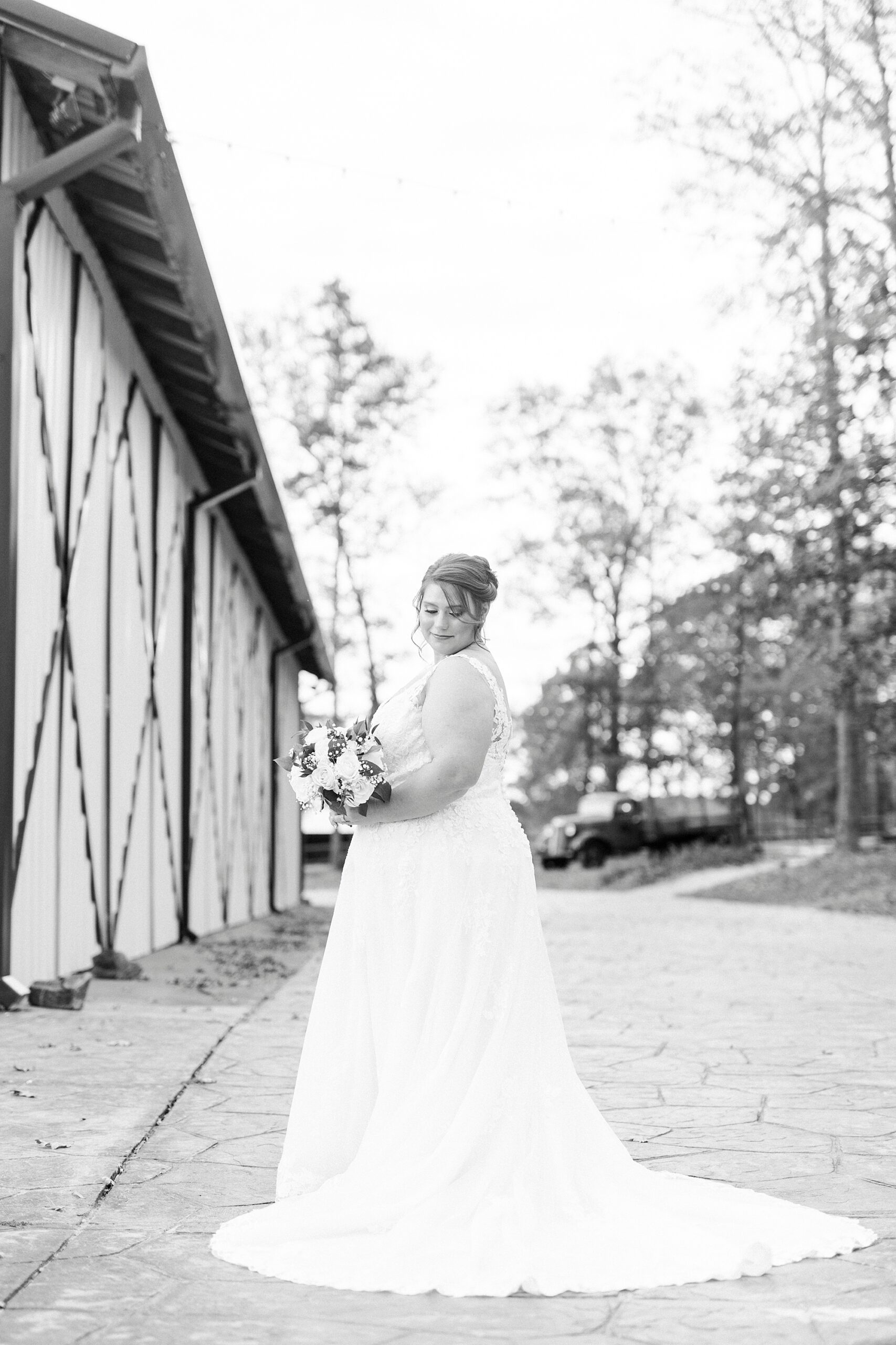bride looks over shoulders holding bouquet of flowers during bridal portraits