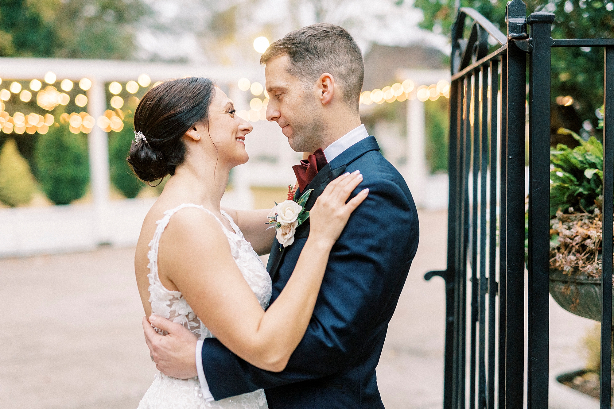 groom hugs bride looking at her new wrought iron gate at Separk Mansion 
