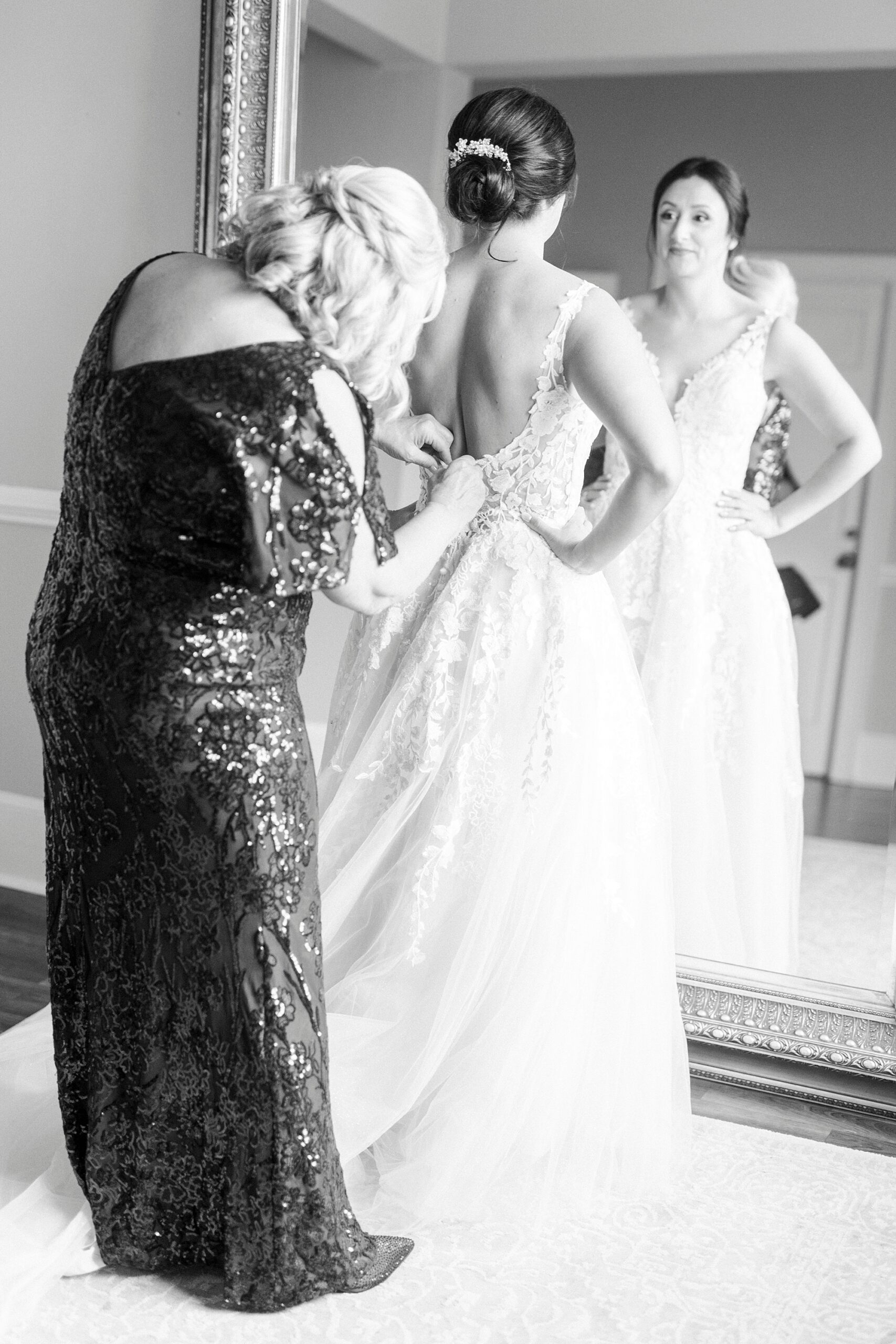 mother helps bride into wedding dress during prep at Separk Mansion