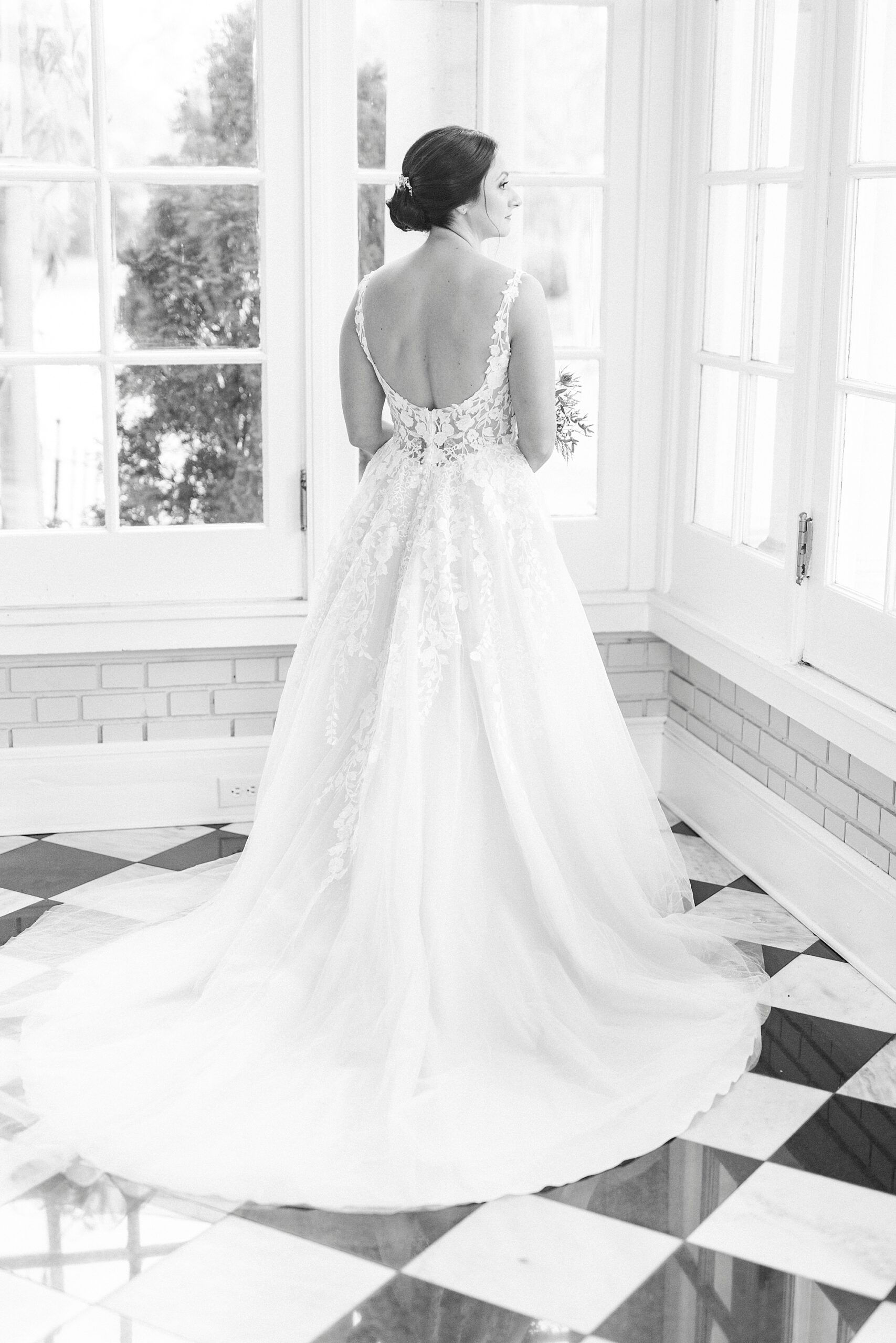 bride stands looking out patio windows inside the Separk Mansion 