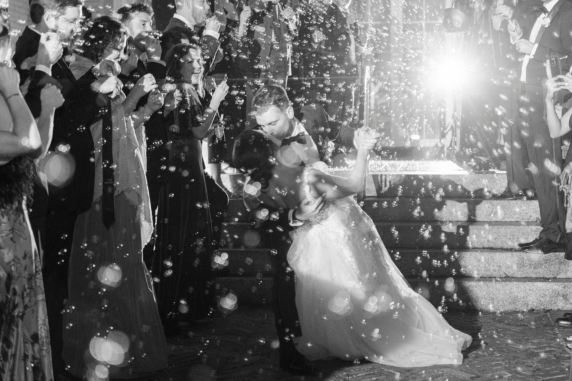 groom kisses bride dipping her during bubble exit from Separk Mansion