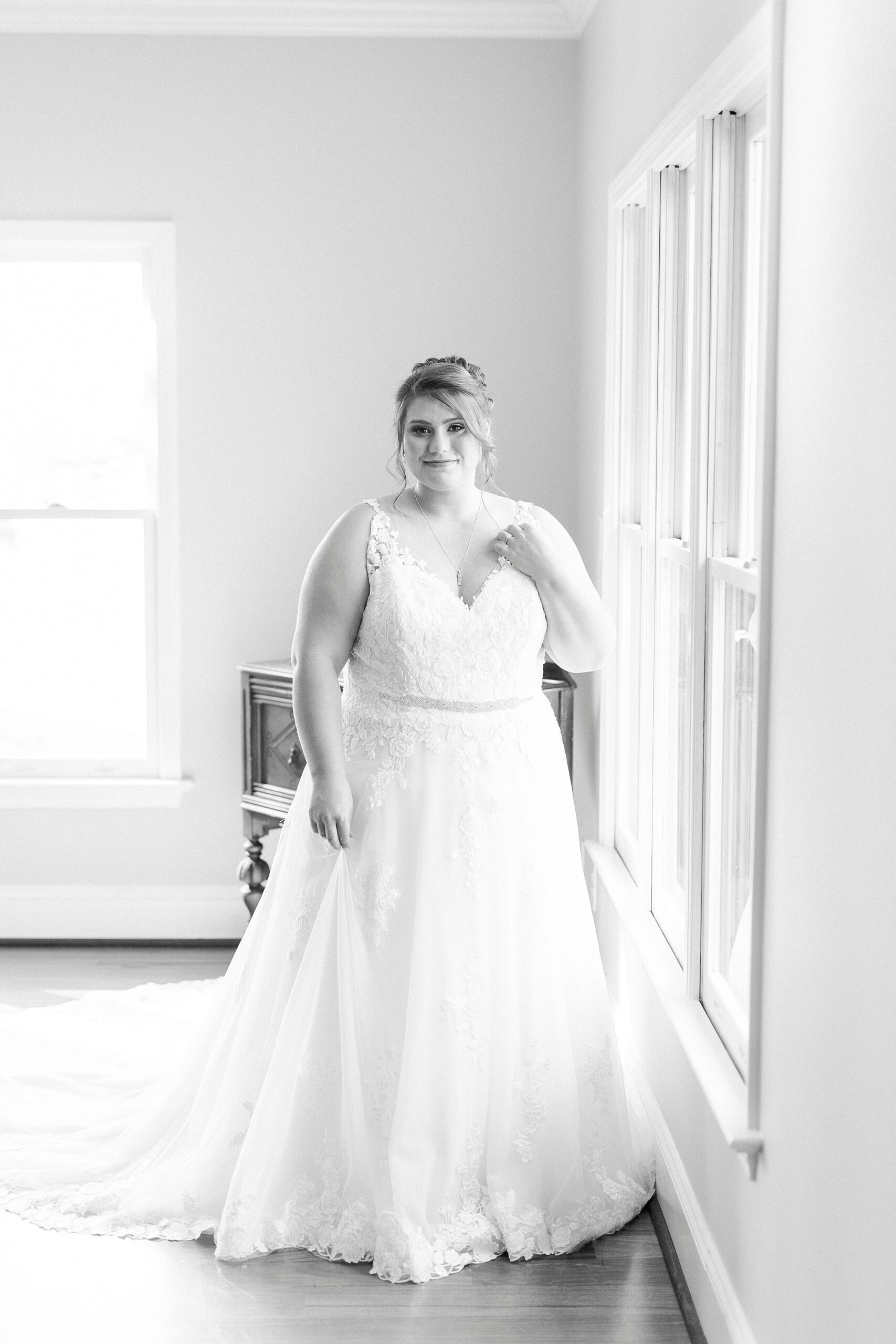 bride poses next to window at the Farm at Brusharbor in wedding gown
