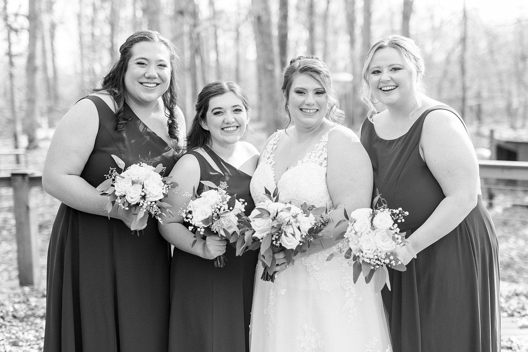 bride and bridesmaids smile holding bouquet of white flowers at the Farm at Brusharbor