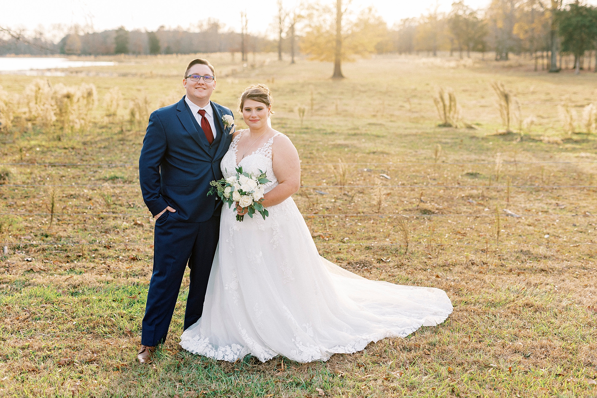 bride and groom hug standing together in field at sunset at the Farm at Brusharbor