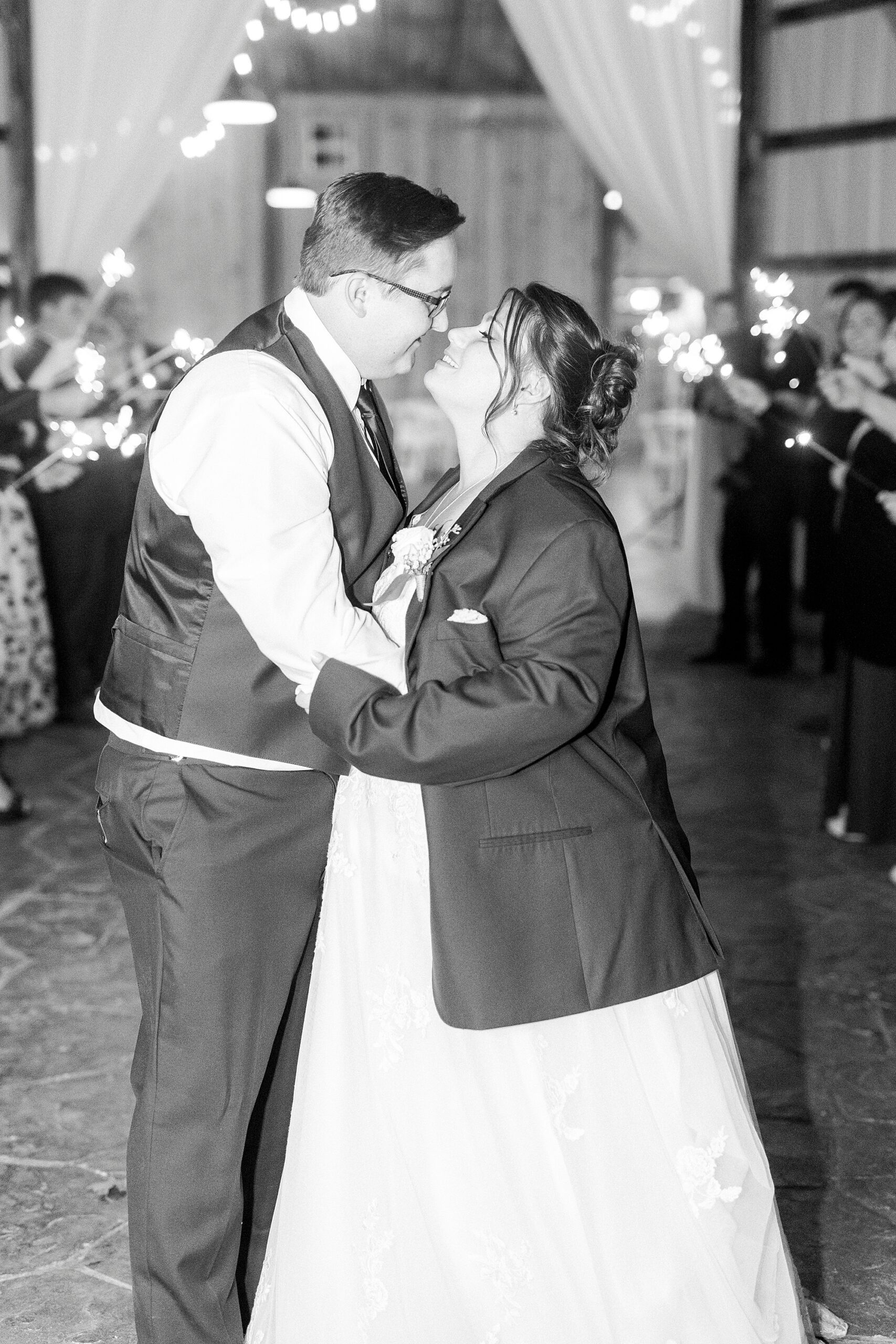 bride and groom lean for a kiss during sparkler exit at the Farm at Brusharbor