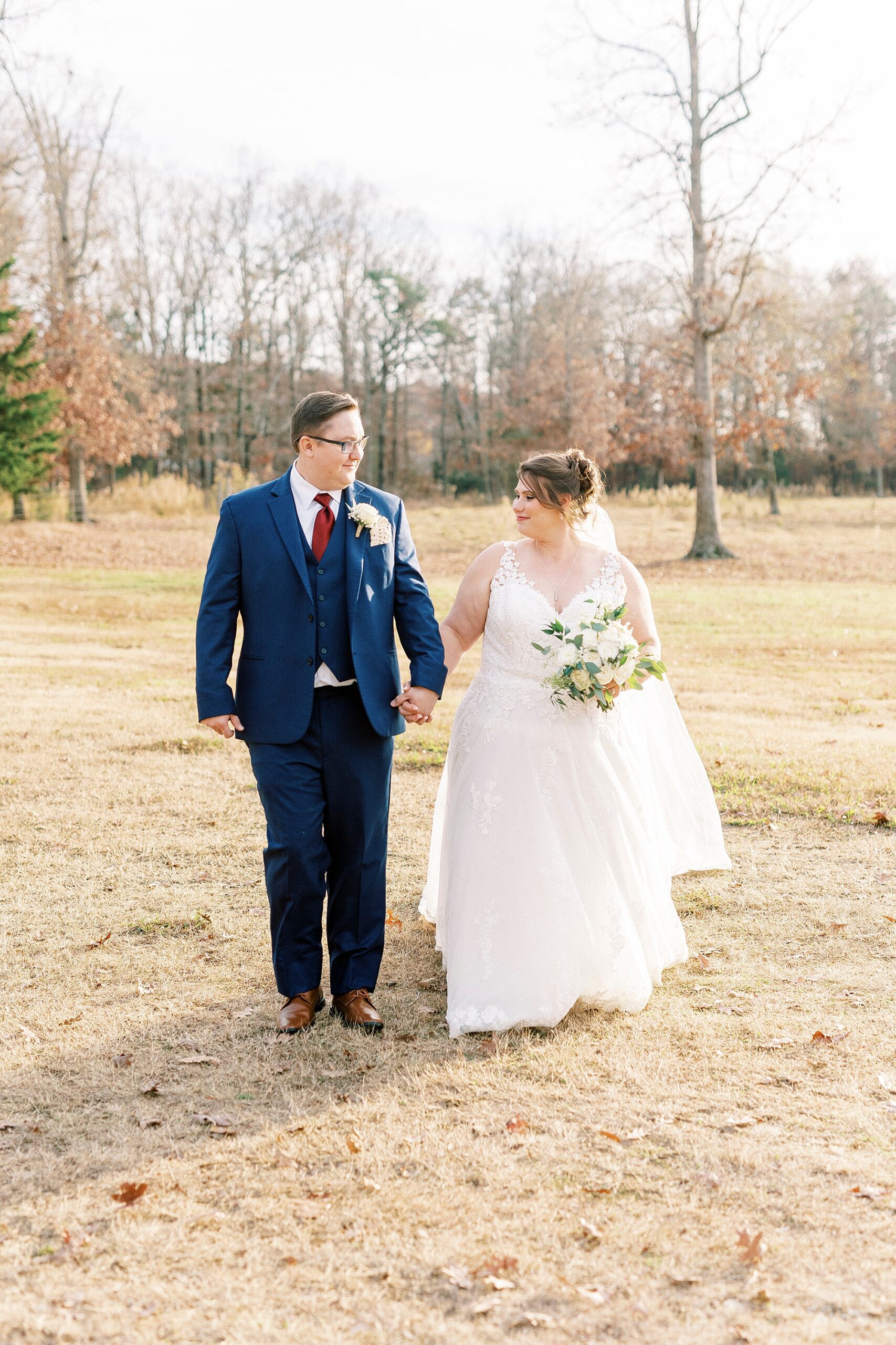 bride and groom hold hands on lawn at the Farm at Brusharbor