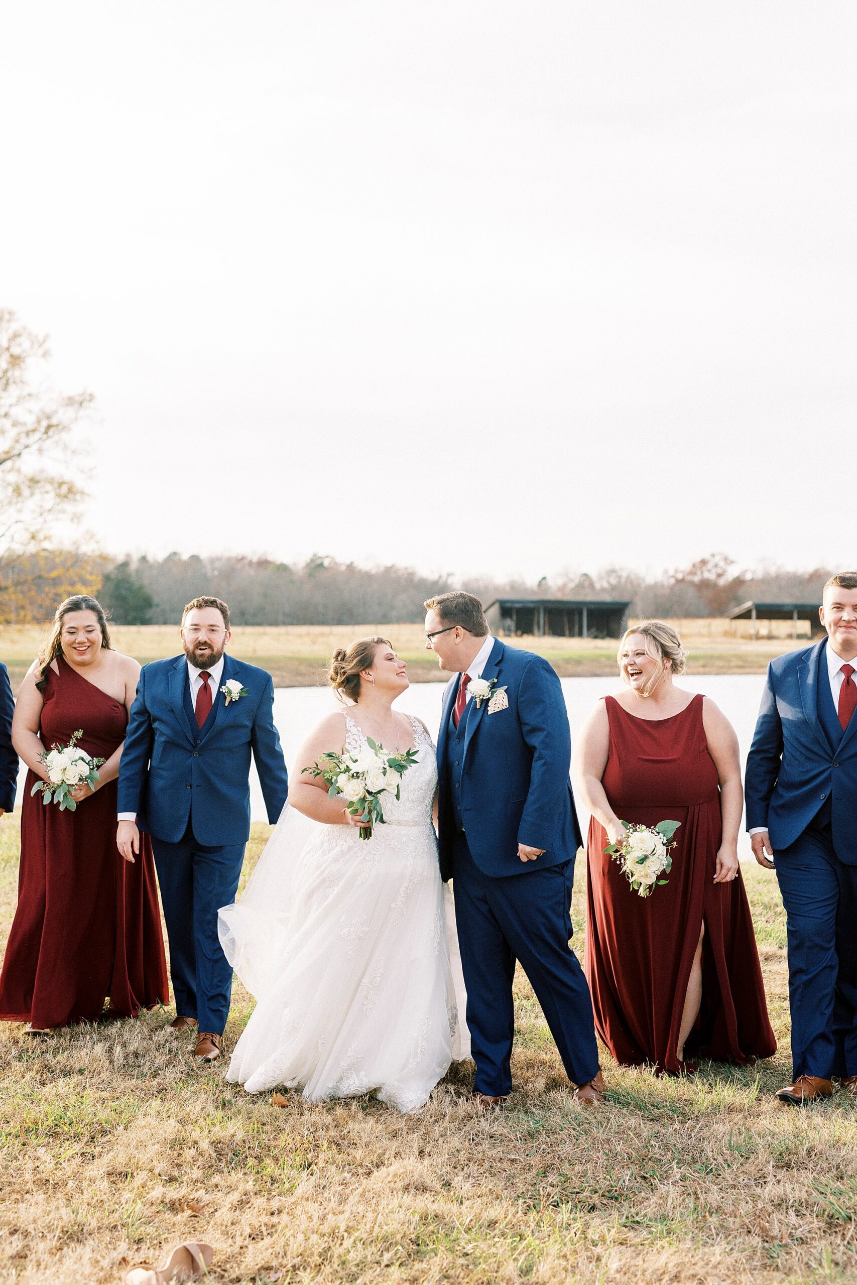 bride and groom look at each other surrounded by bridal party at the Farm at Brusharbor