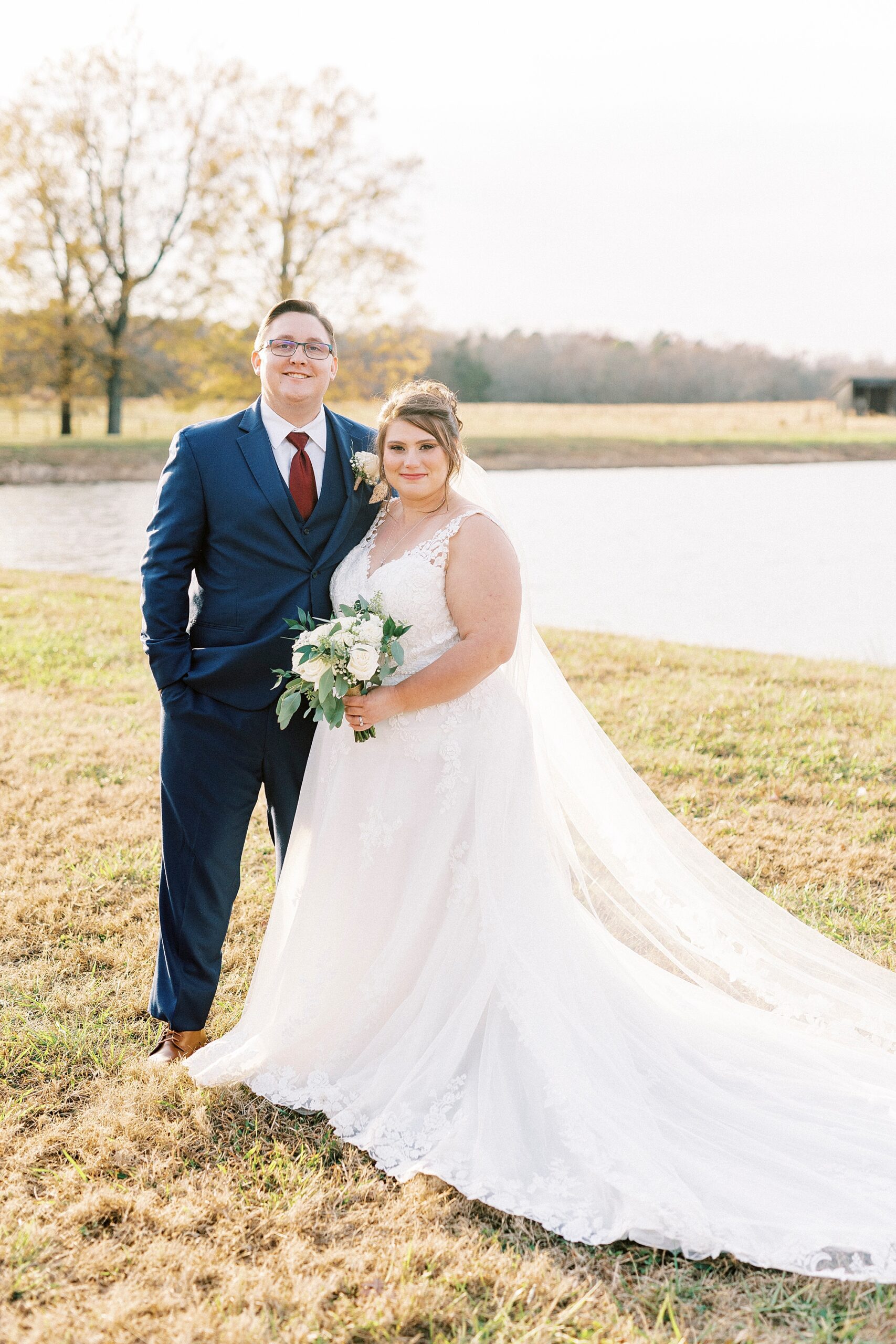 bride and groom hug in front of pond at the Farm at Brusharbor