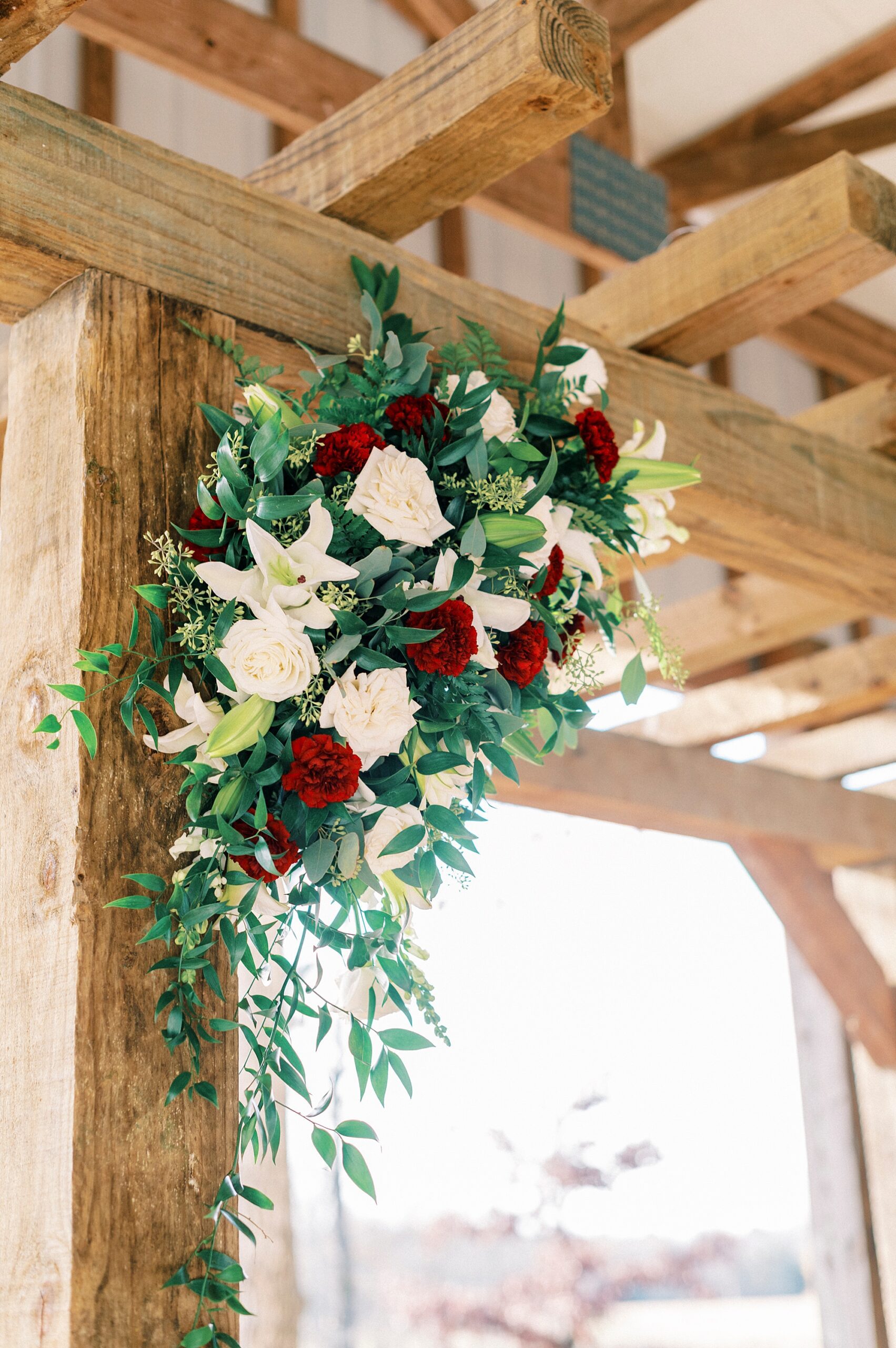 red and white flowers hang on wooden arbor at the Farm at Brusharbor