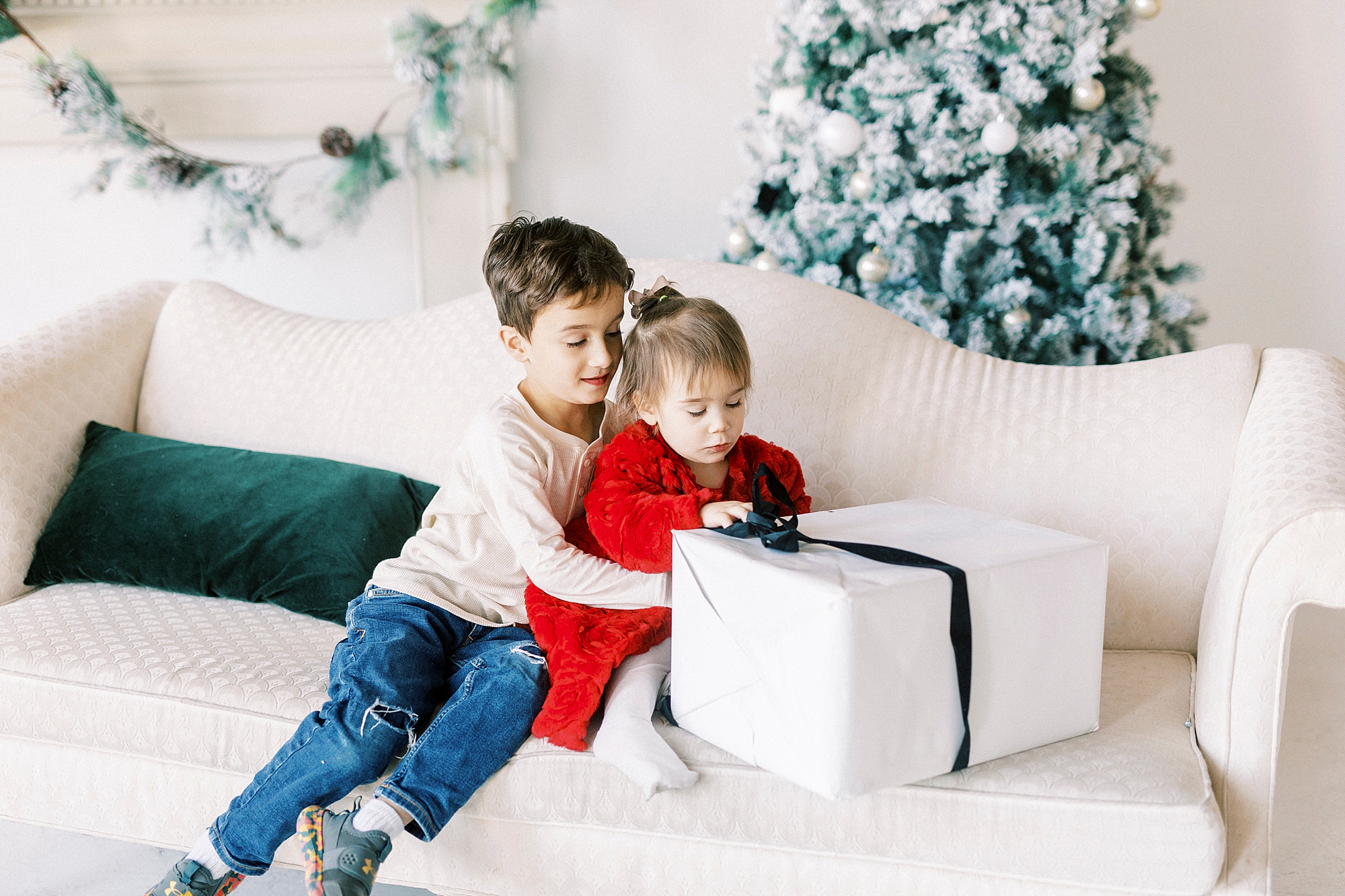siblings play during Christmas portraits in Downtown Concord studio