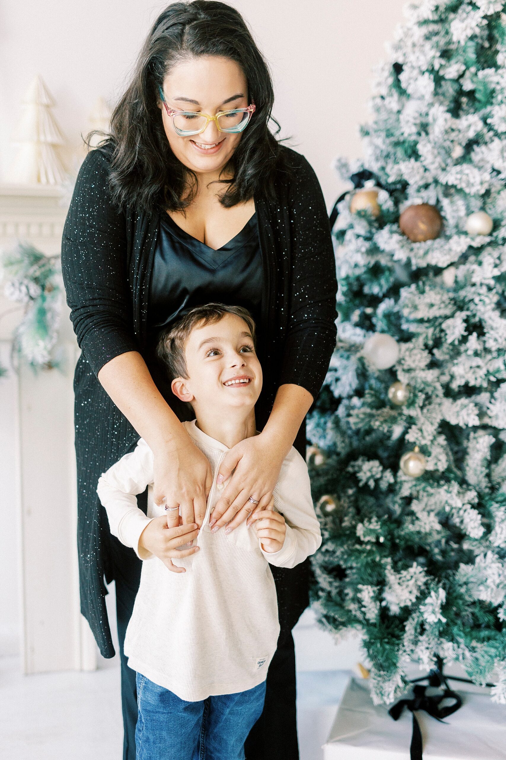 mom hugs son in front of her during portraits in Concord NC studio