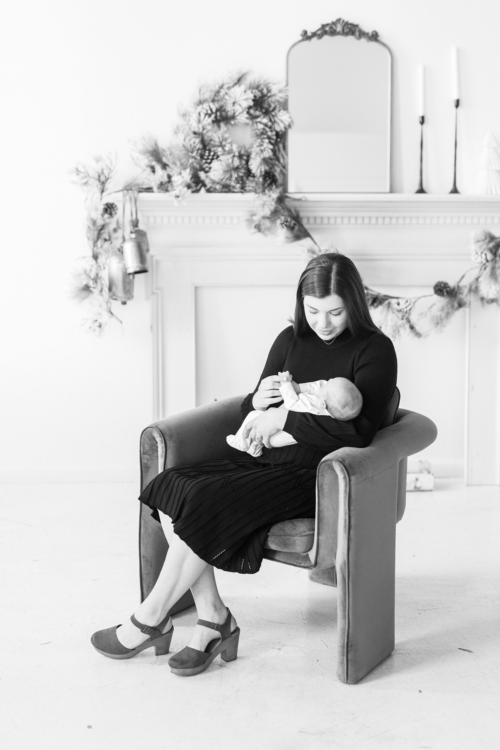 mom rocks son during studio Christmas portraits in Downtown Concord looking down at baby