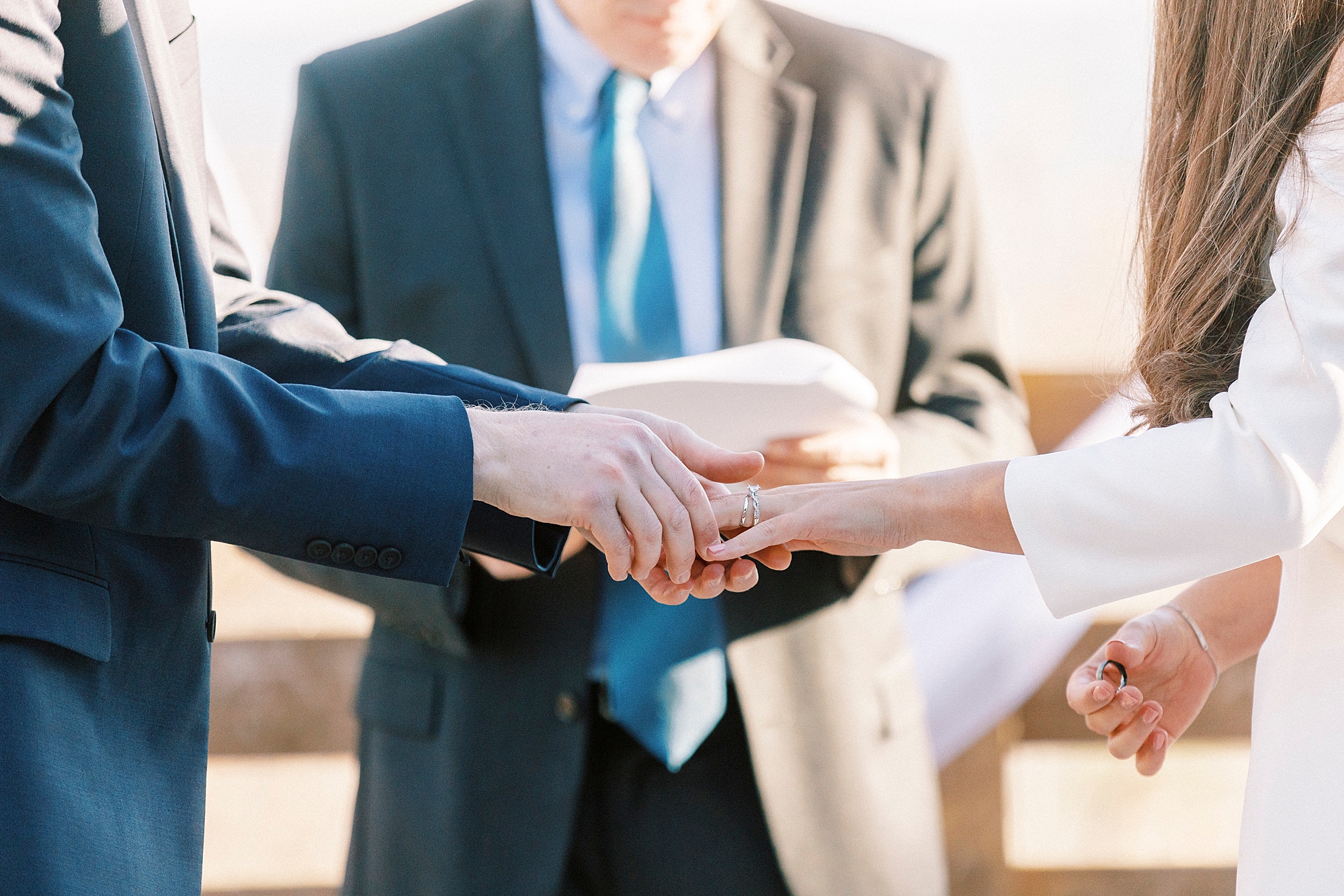 bride and groom hold hands exchanging rings during early morning Morrow Mountain wedding ceremony