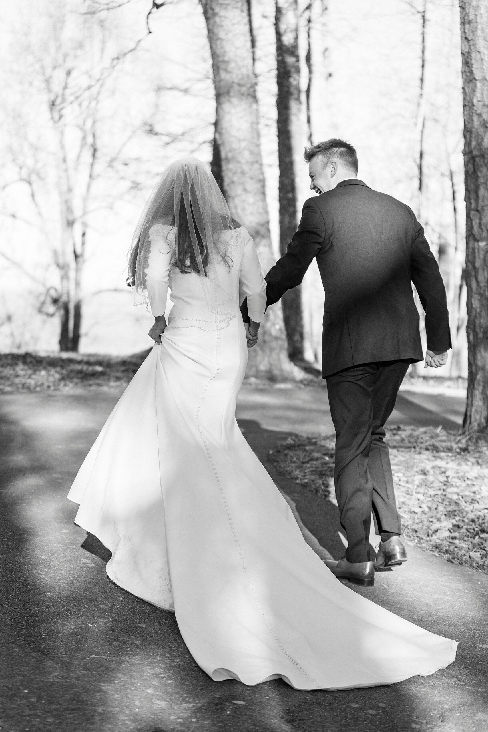 bride and groom hold hands walking up hill after early morning Morrow Mountain wedding ceremony