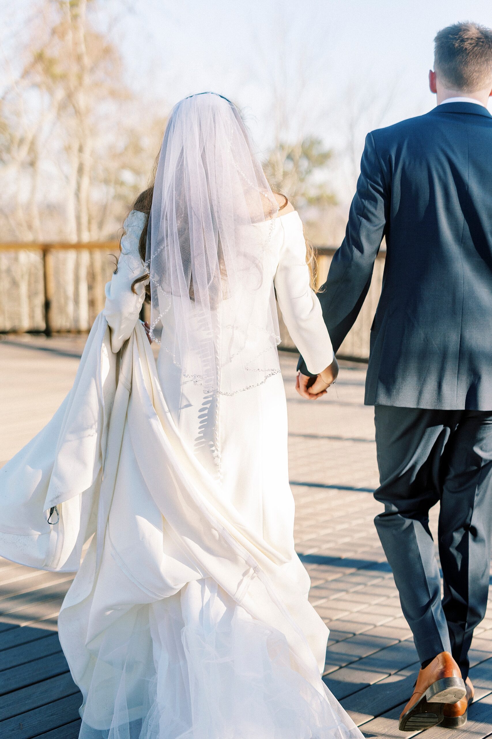bride and groom hold hands leaving early morning wedding ceremony on Morrow Mountain