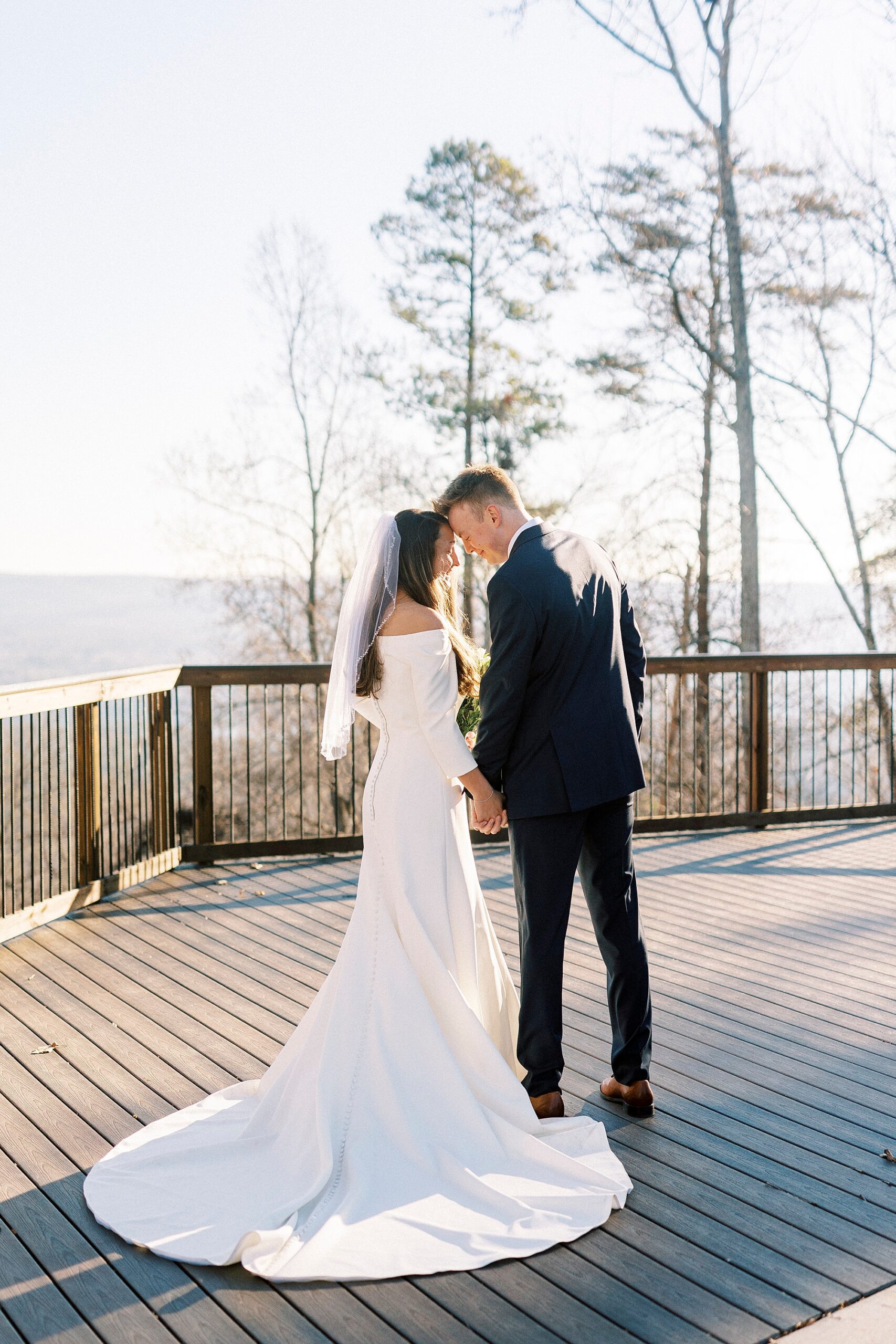 newlyweds lead heads together during portraits on Morrow Mountain