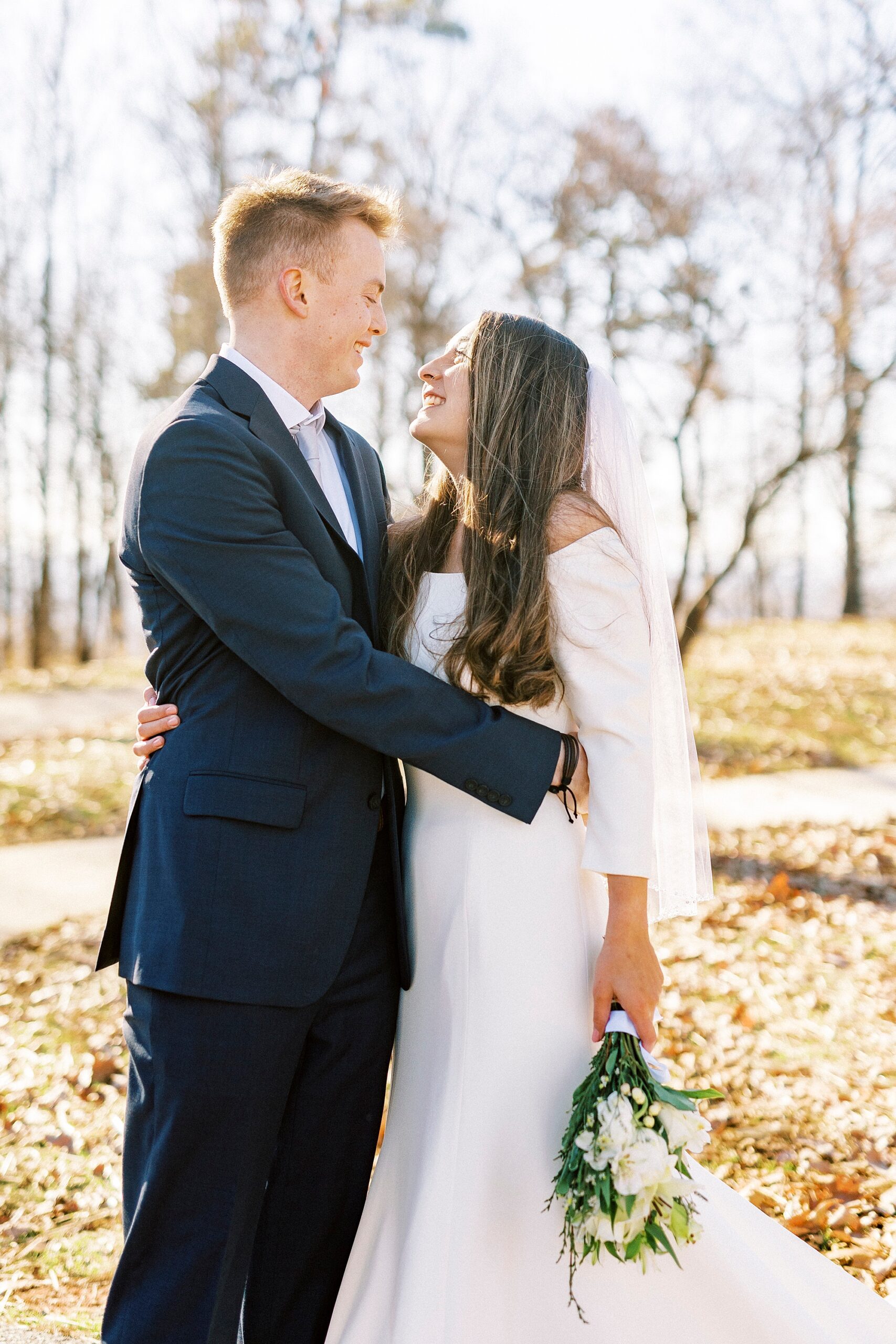 newlyweds smile looking at each other during early morning wedding on Morrow Mountain
