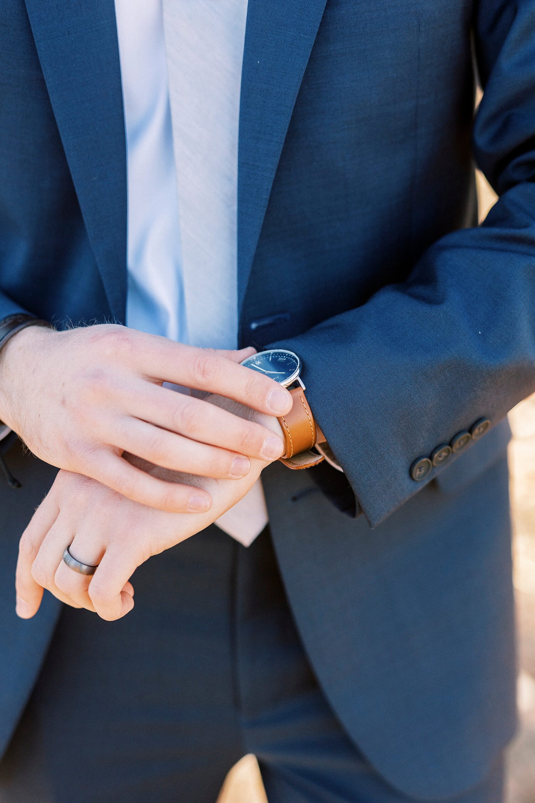 groom adjusts watch during early morning wedding on Morrow Mountain