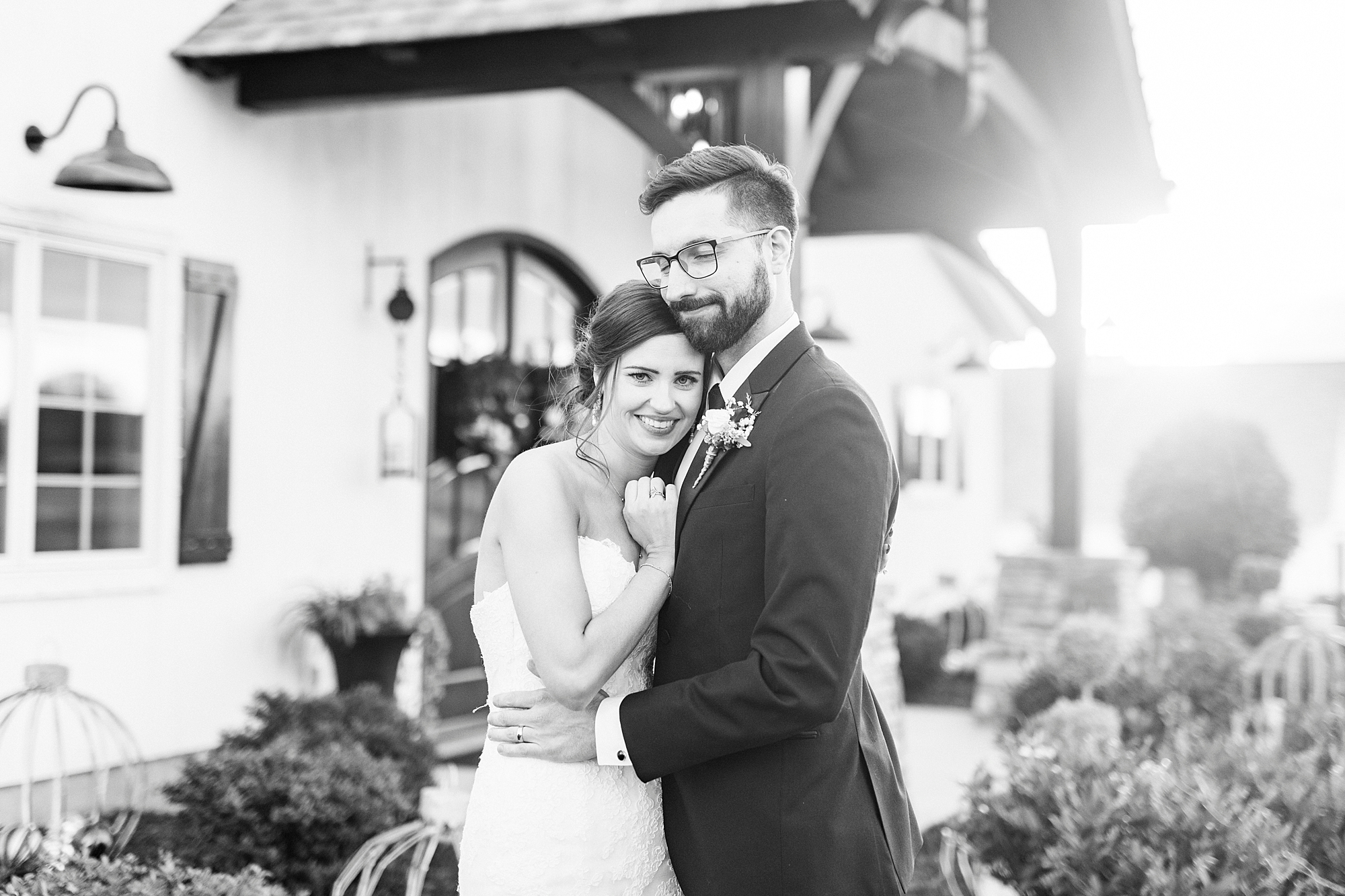 bride and groom hug in front of chapel at Chickadee Hill Farms