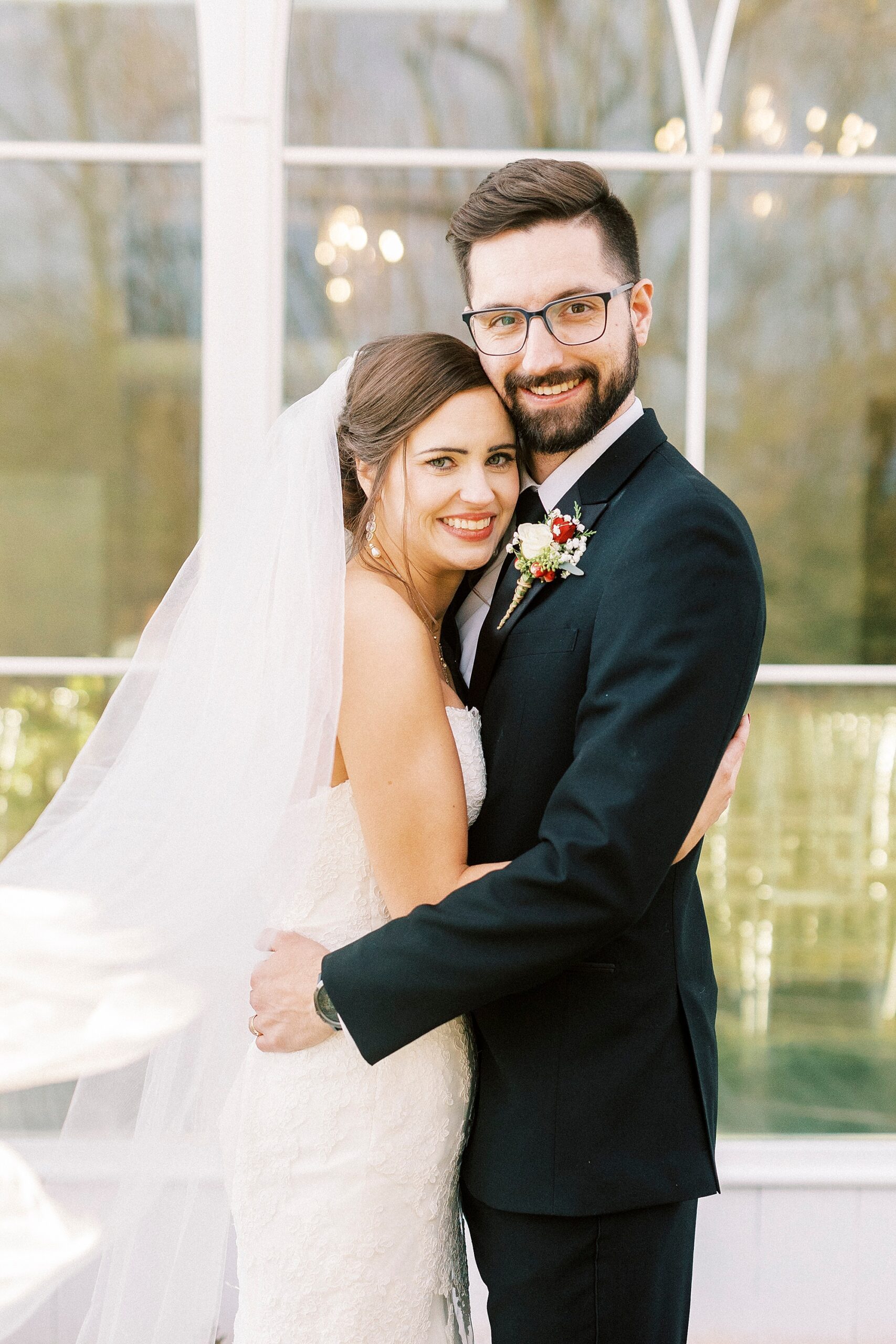 newlyweds hug in front of chapel at Chickadee Hill Farms