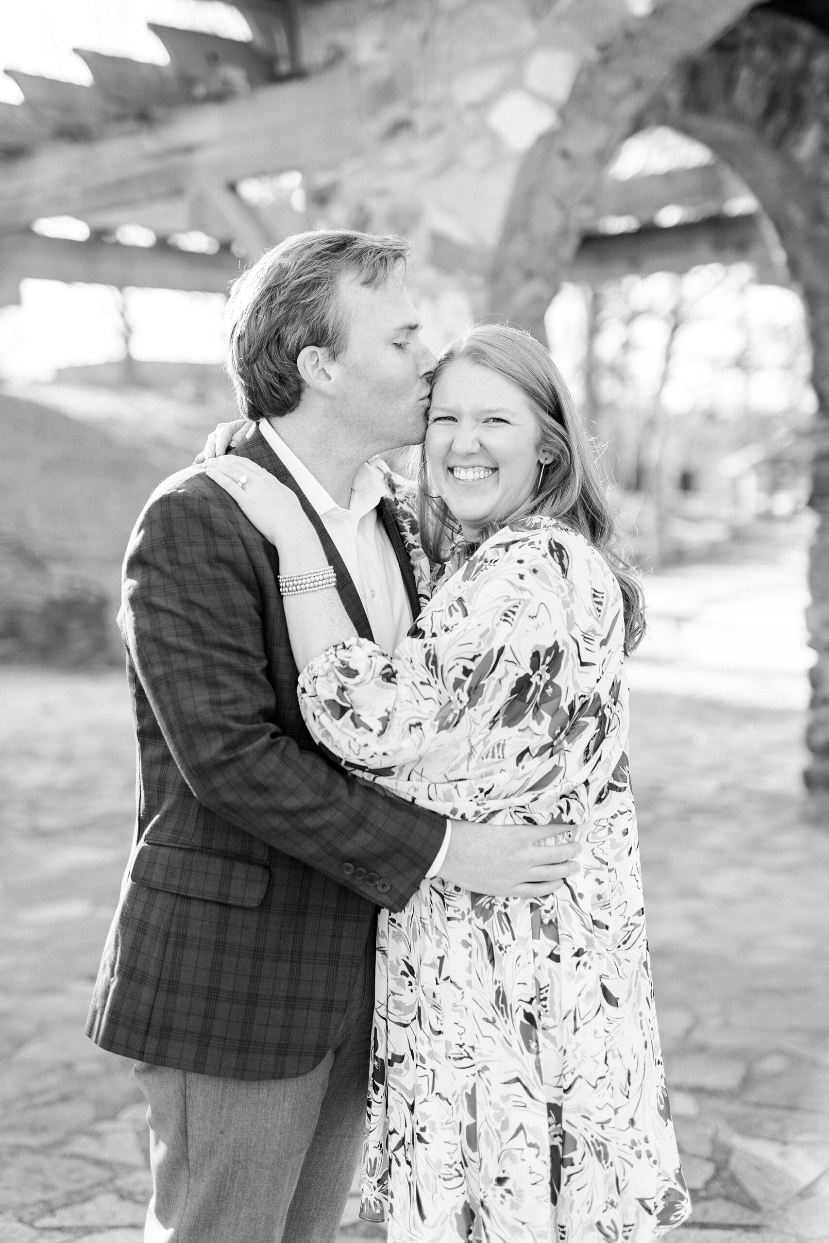 man kisses woman's forehead during Independence Park engagement portraits