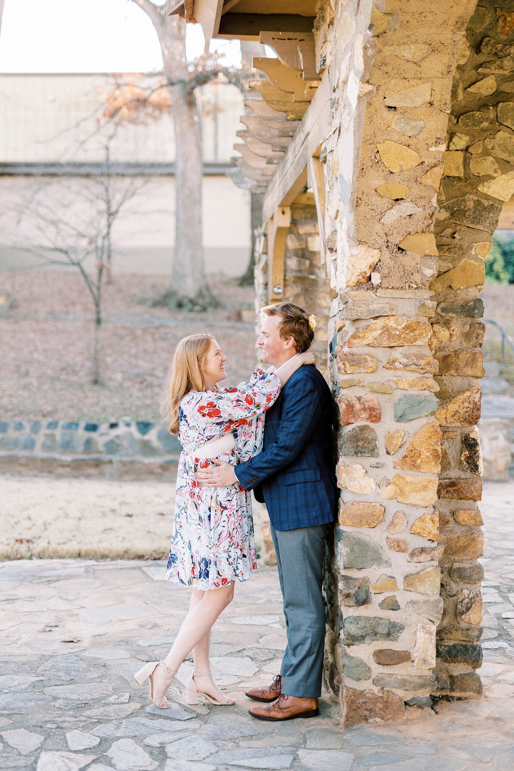 couple hugs leaning against pillar at Independence Park in Charlotte NC