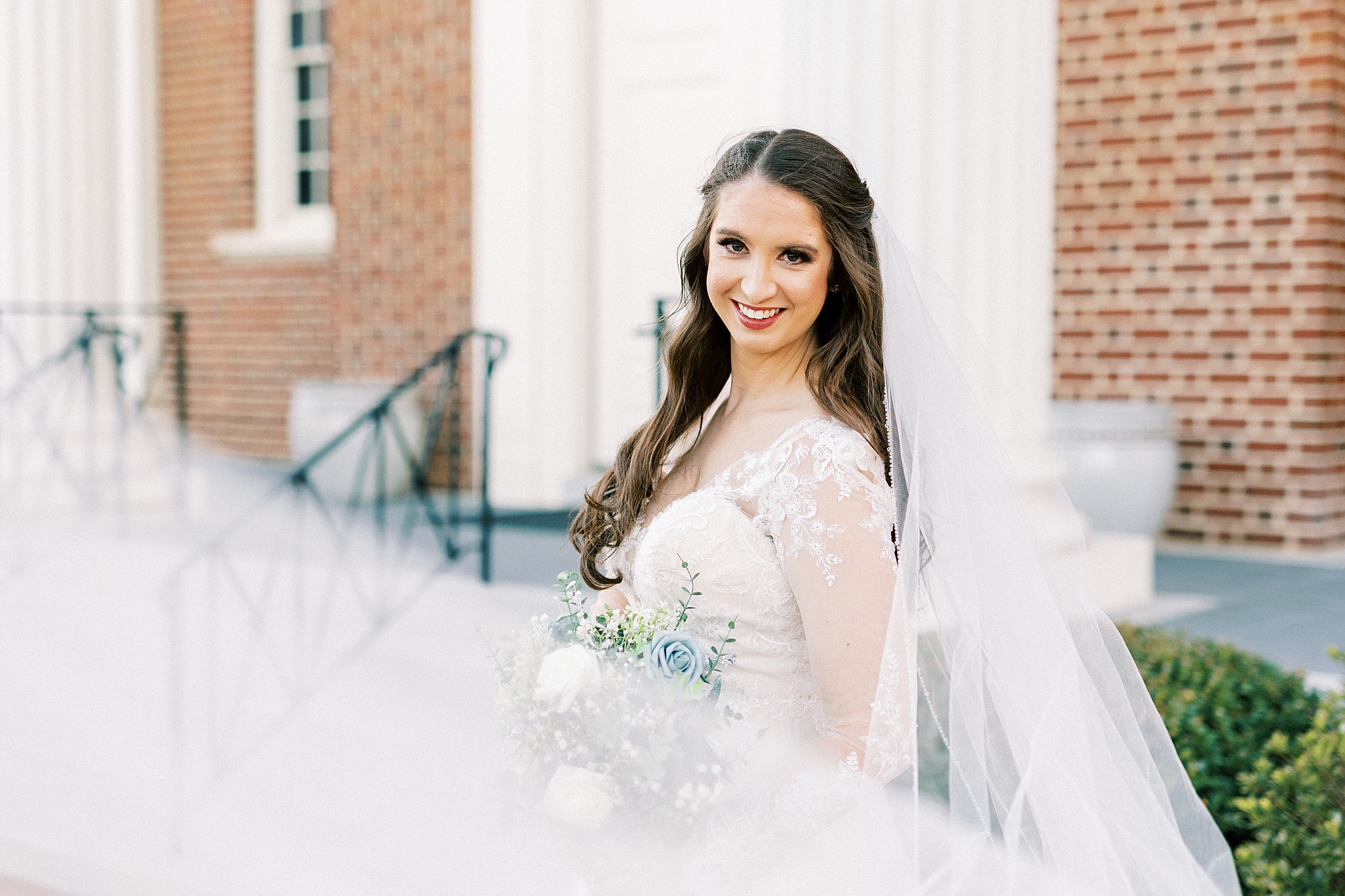 bride leans against a church in Downtown Kannapolis