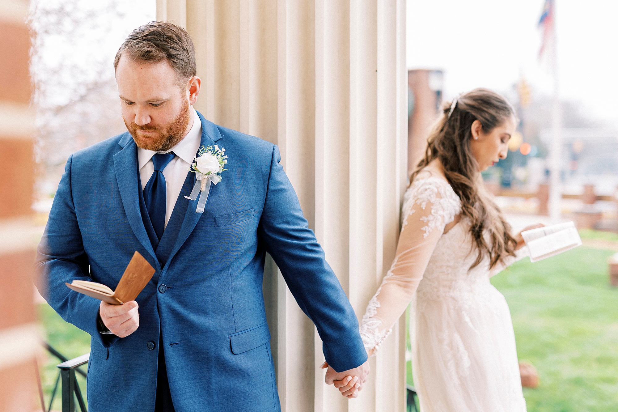 bride and groom hold hands around column of First Baptist Church in Kannapolis NC during first touch