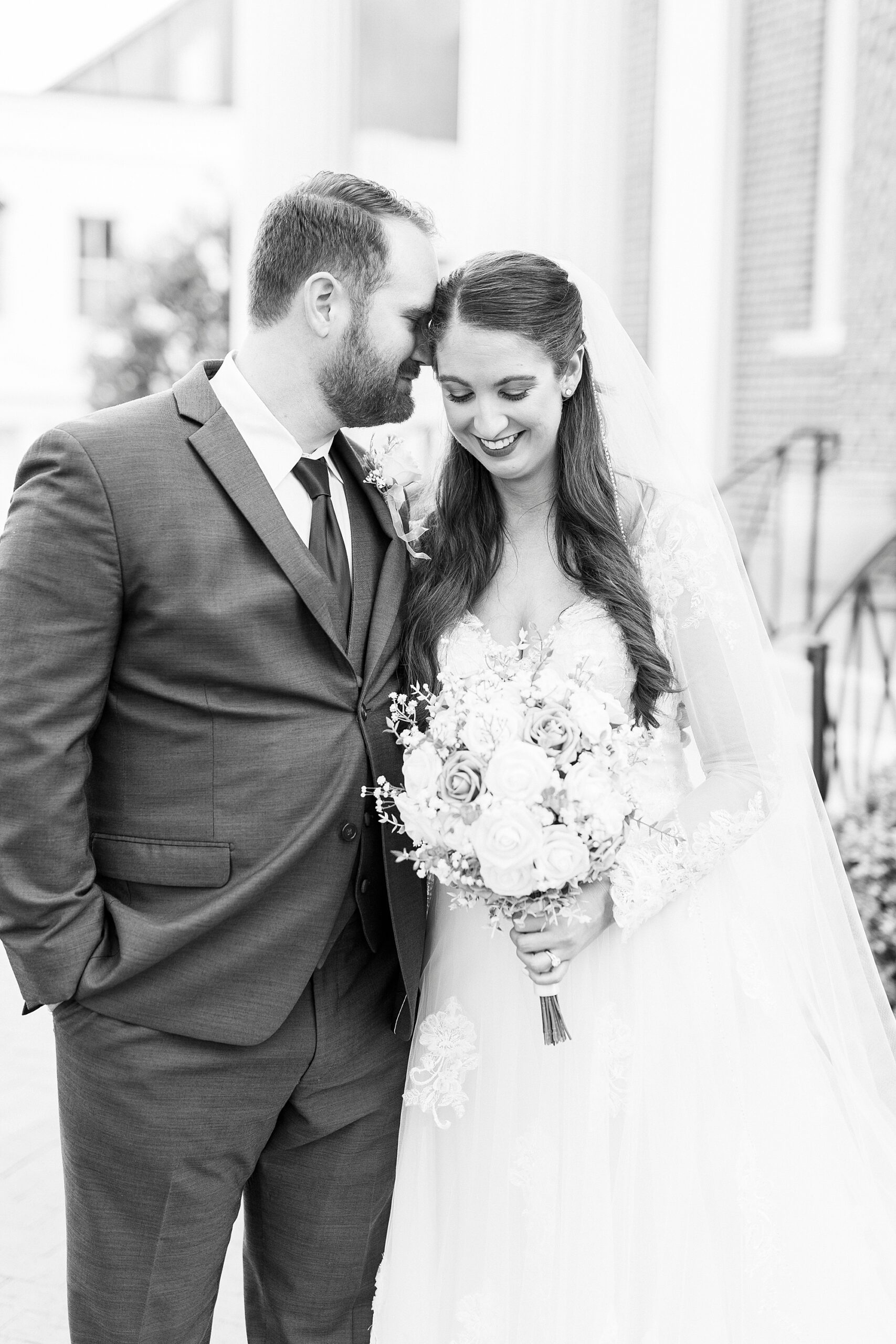 bride and groom hug while groom nuzzles bride's cheek