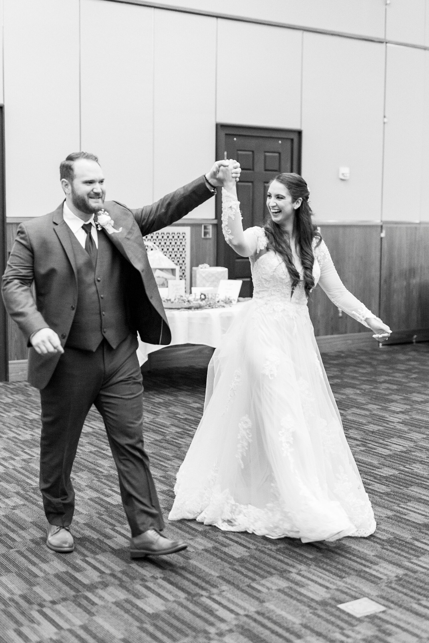 bride and groom cheer and laugh walking into NC reception