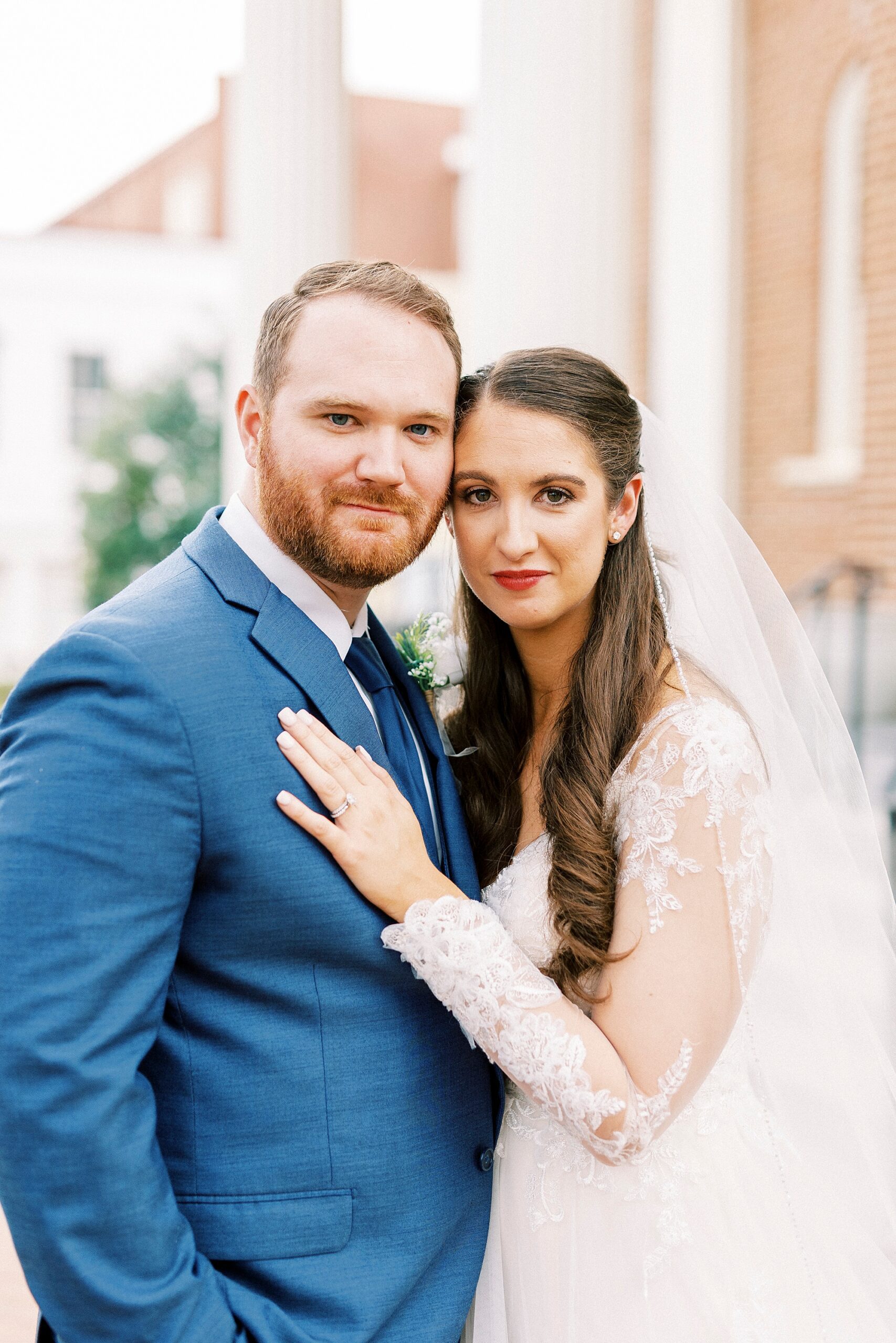 newlyweds hug leaning heads together in Downtown Kannapolis